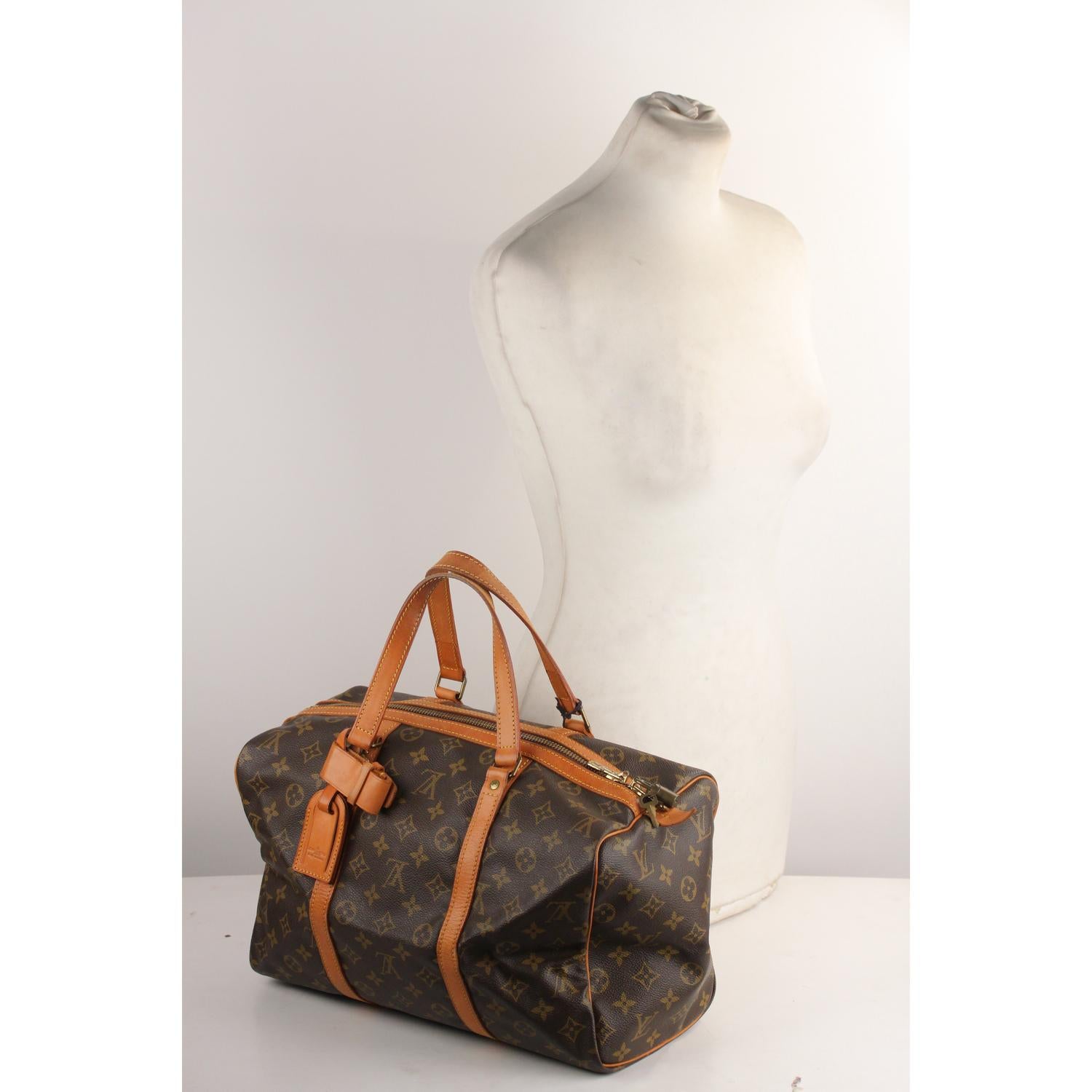 Louis Vuitton classic Monogram Canvas vintage 'Sac Souple' 35. Upper zipper closure with Louis Vuitton Padlock and keys. Double leather handles. Brown fabric lining. 'Louis Vuitton Paris - made in France' engraved on leather piece on the side.