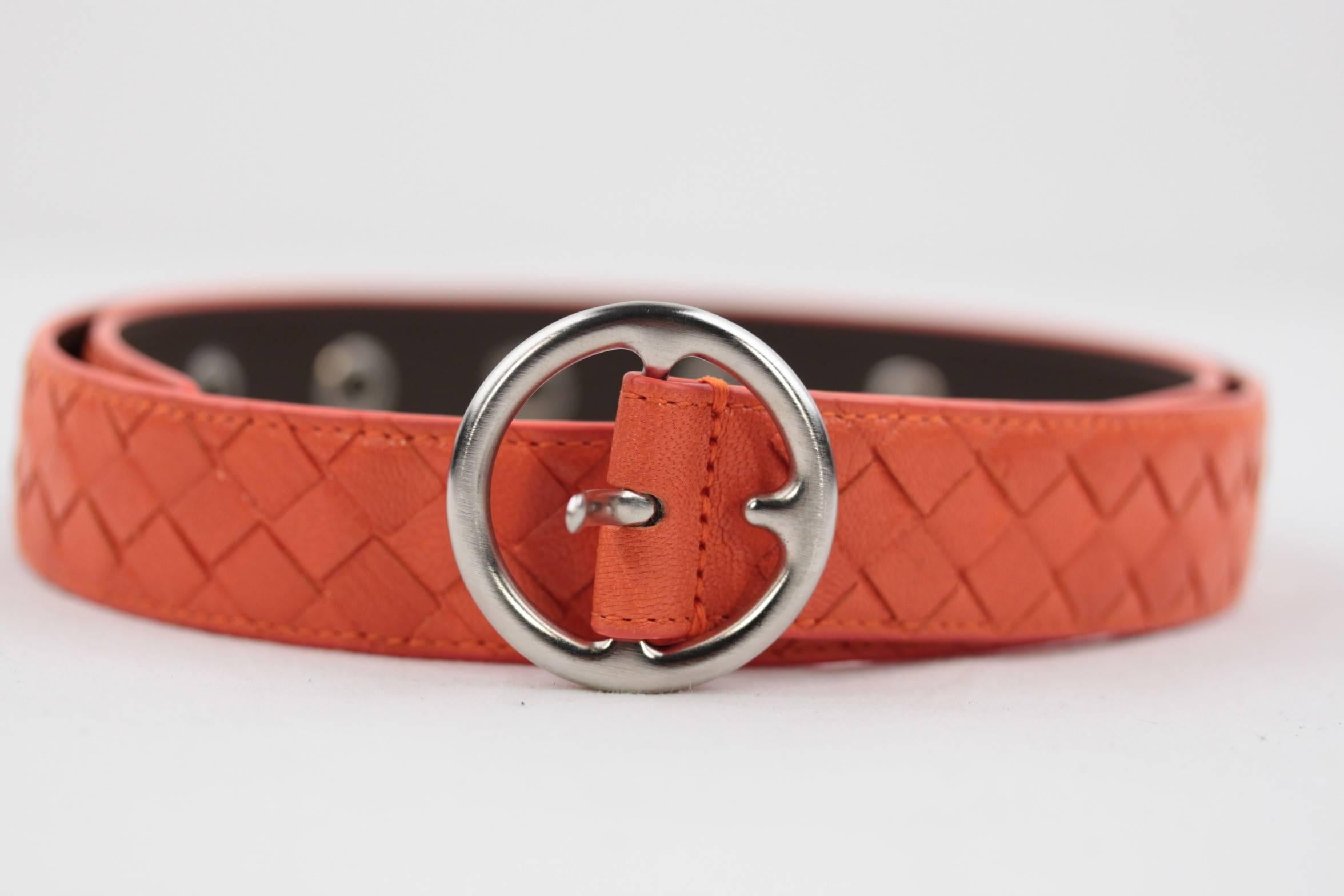 - Color: Orange
- Intrecciato woven leather strap with smooth leather underside
- Matte silver metal round buckle - Single prong closure
- 5-hole adjustment
- Size: 80 /32 (the size is engraved on the reverse of the belt)
- 1 1/2 inches - 3,7