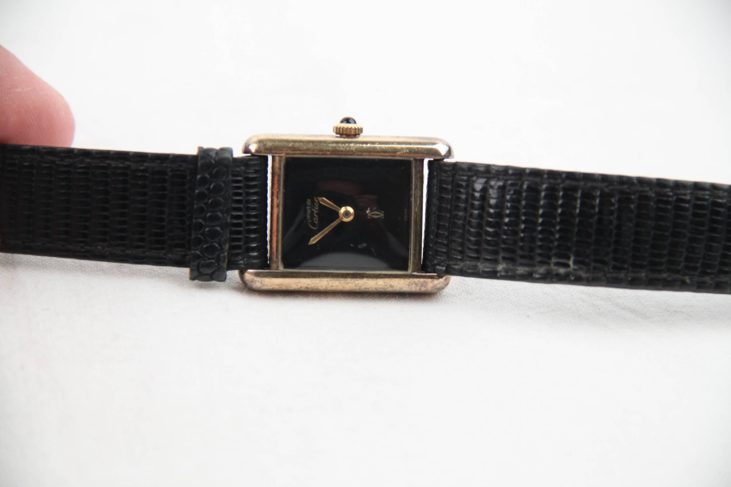 - Black dial signed 'Must de Cartier - CC - Swiss'.
- Original golden hands
- Original 925 solid silver case, gold plated
- 'Argent plaque OR G 20M, Cartier, Paris, #3 015088, Swiss' engraved on the reverse of the watch
- Black lizard skin