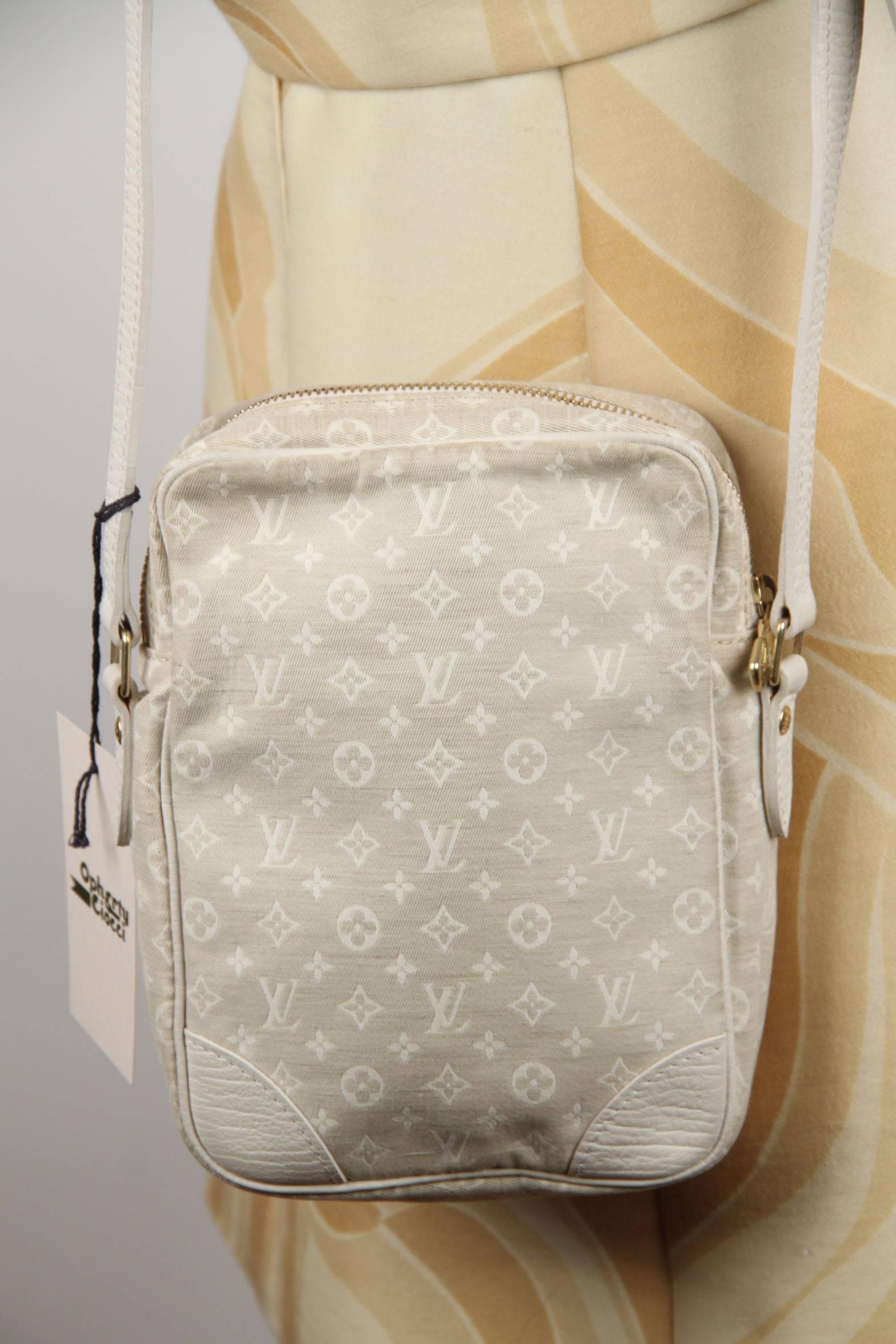 This stylish DANUBE messenger bag is beautifully crafted of cotton and linen Louis Vuitton monogram MINI LIN canvas in a shade of beige. The bag features brown leather trim including a patch pocket and a cross body strap with gold metal hardware.