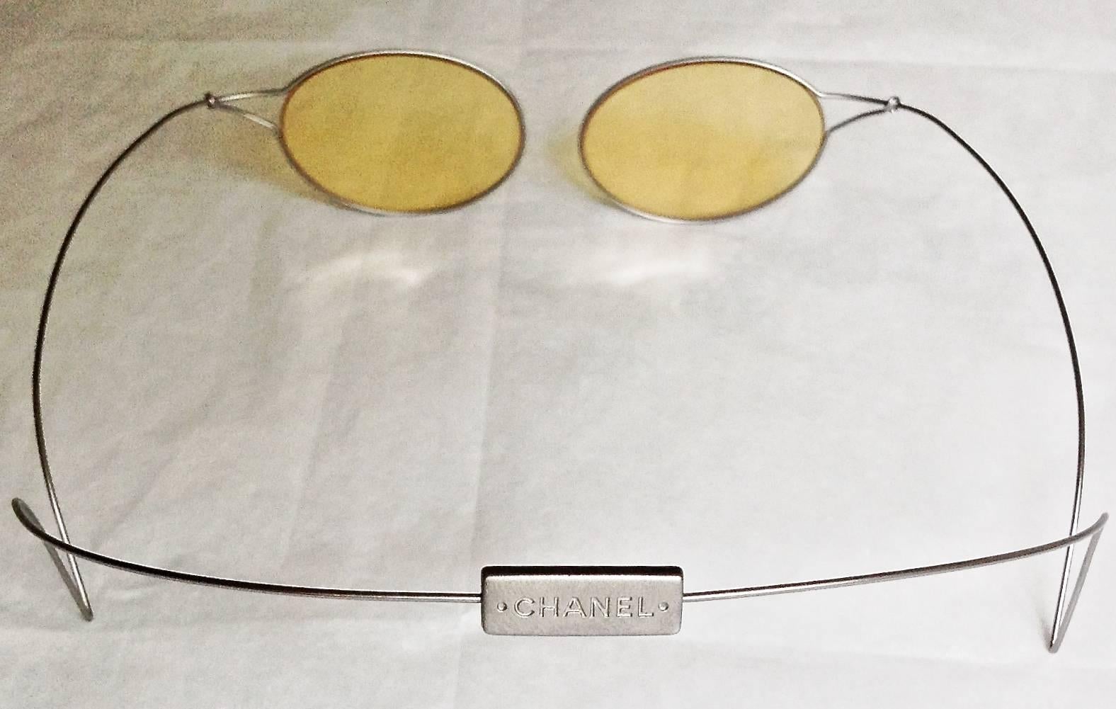 Bordo molto raro e design divertente di Chanel con la sua scatola dal design insolito.  Aste di metallo morbido da far scorrere dietro la testa.  Conor delle lenti : Giallo  LARGHEZZA DEL VETRO: 4,8 CM CIASCUNO. 
CONDIZIONE Le lenti sono in ottime