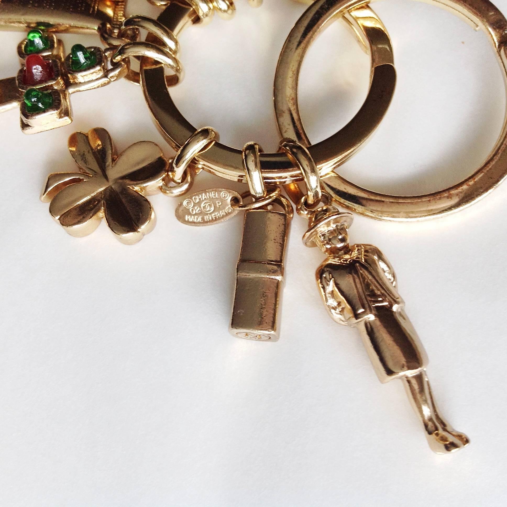 This collectors' 2002 P double rings keyring is so complete with all iconic charms, such as sunglasses, heart, Gripoix glass cross, facial cream, shamrock, lipstick, Coco herself, sanders an CC logo. This key ring can be also used as a necklace