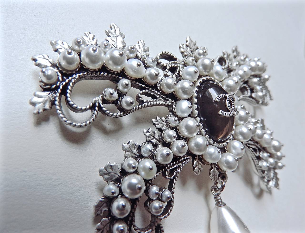 This impeccable elegant brooch is from 2015 Chanel Métiers d'Art Paris-Salzburg collection. Exquisitely handmade with antique like silver plating metal and embellished with fresh water pearls, large teardrop Gripoix glass pearl, then adorned with