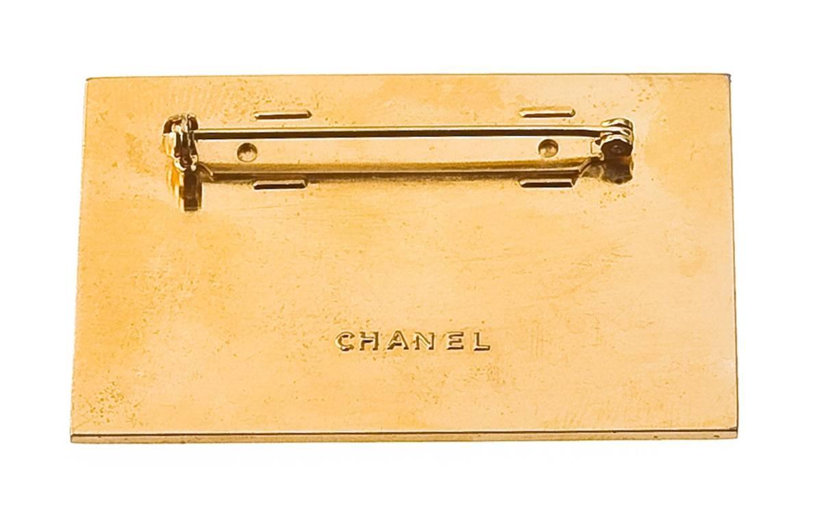 Vintage Chanel brooch with "Chanel Paris" and CC logos.