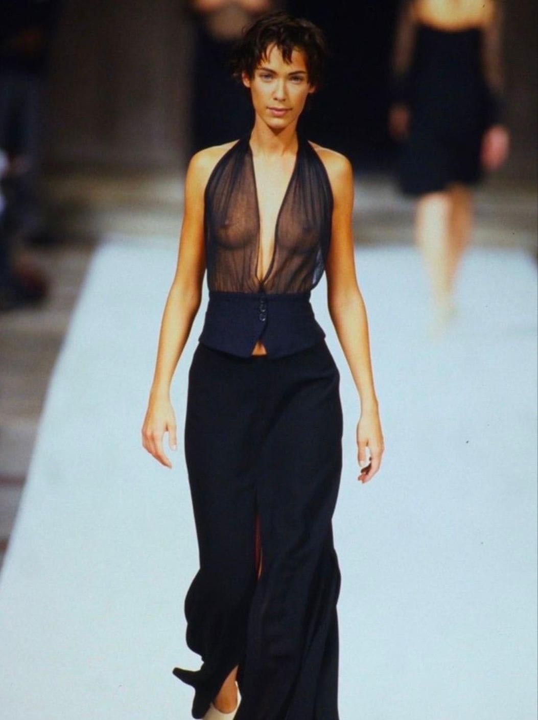 From the Spring/Summer 1995 collection, this ultra-sexy grey Ann Demulemeester top debuted on the season's runway. Featuring a plunging neckline and sheer bust, this vest-style top is made complete with an exposed back, halterneck tie, and button