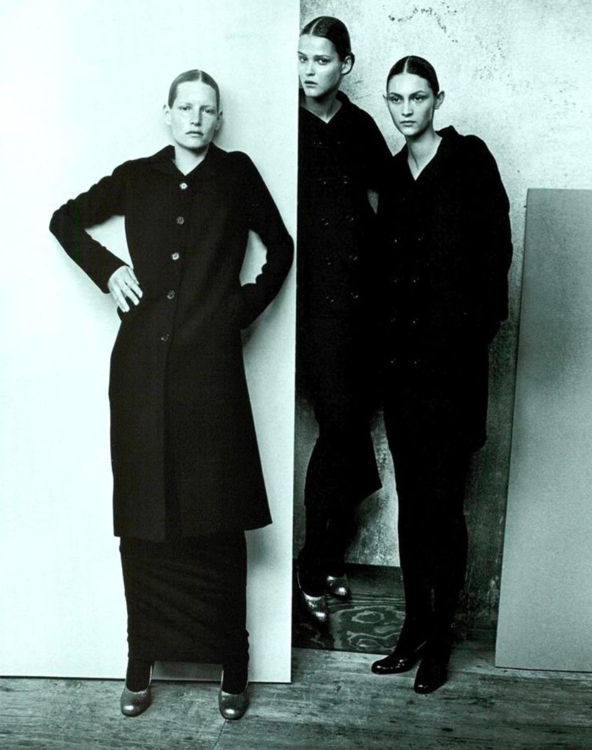 Questo cappotto oversize in lana nera di Dolce & Gabbana della collezione Autunno/Inverno 1998 ha debuttato sulla passerella della stagione, modellato da Christina Kruse. Questo design minimalista è caratterizzato da una silhouette longilinea,