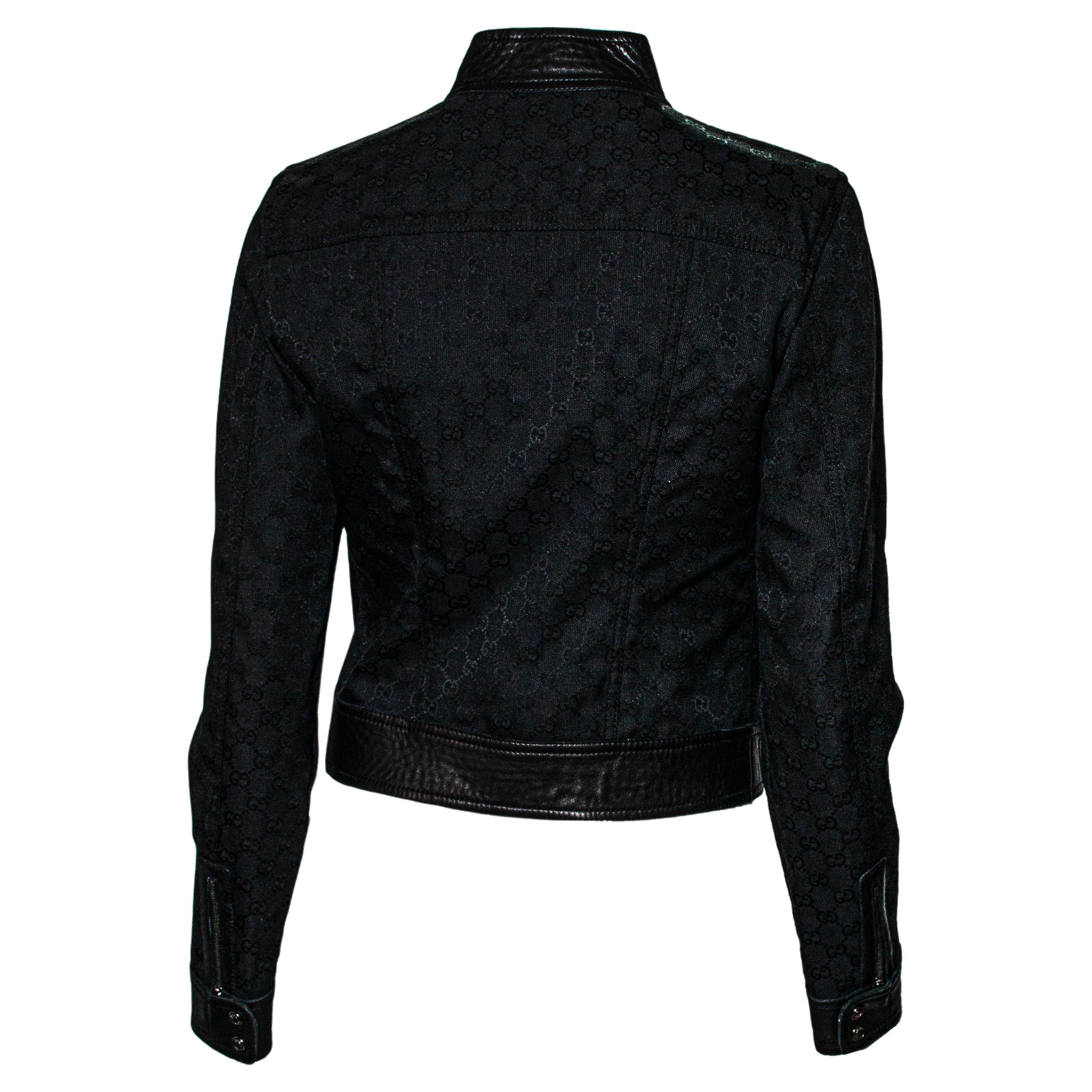Mehr Gucci geht nicht... Diese von Tom Ford für die F/W 2000-Kollektion entworfene Jacke besteht aus Leder und ist mit einem schwarzen Gucci-Monogramm aus Canvas überzogen. Dieses Stück hat zwei Reißverschlusstaschen am Vorderteil und einen