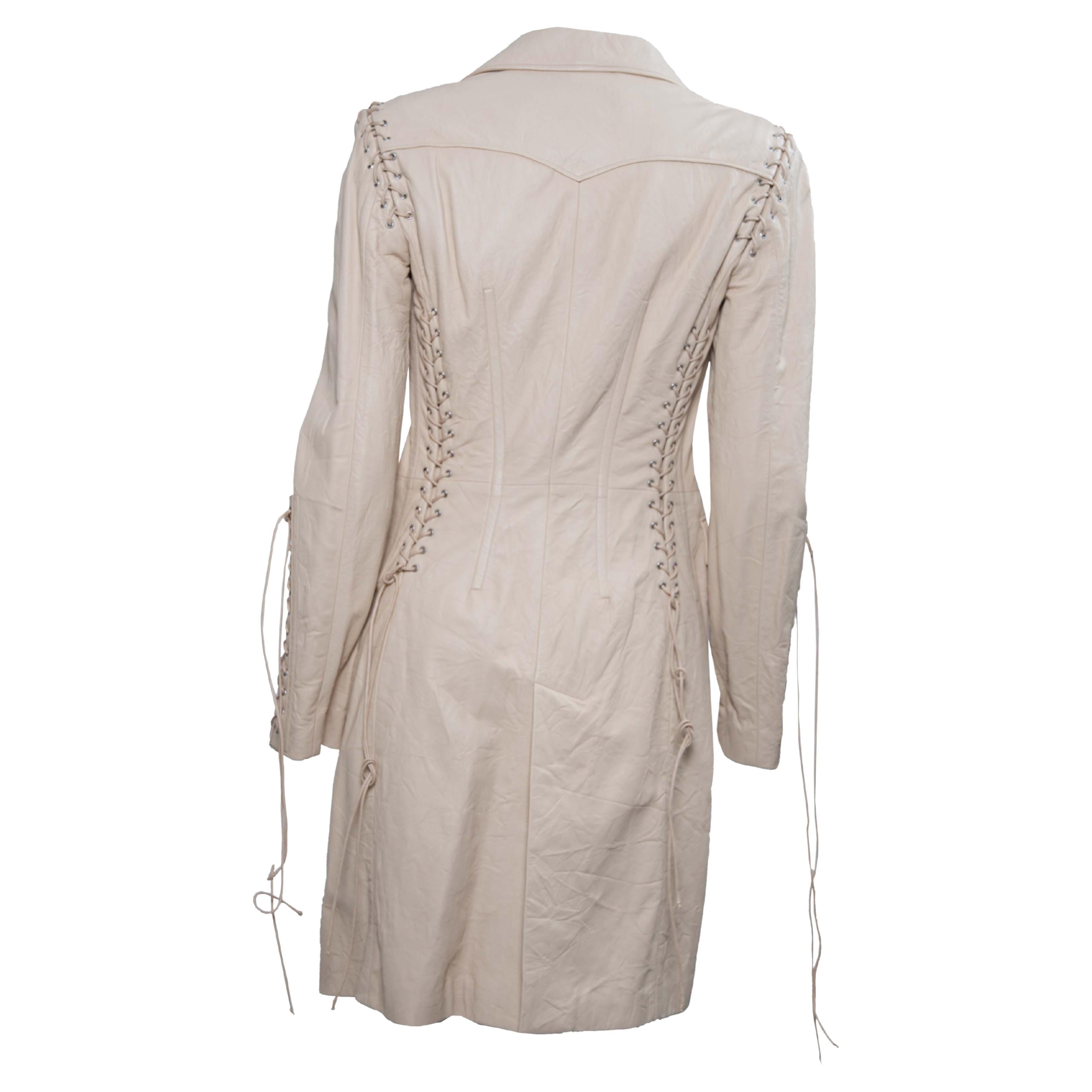 Ti presentiamo un trench Versace in morbida pelle stringata disegnato da Donatella Versace. La collezione A/I 2003 presenta giacche simili a questa sulla passerella di quella stagione. Realizzato in pelle volutamente stropicciata, questo cappotto è