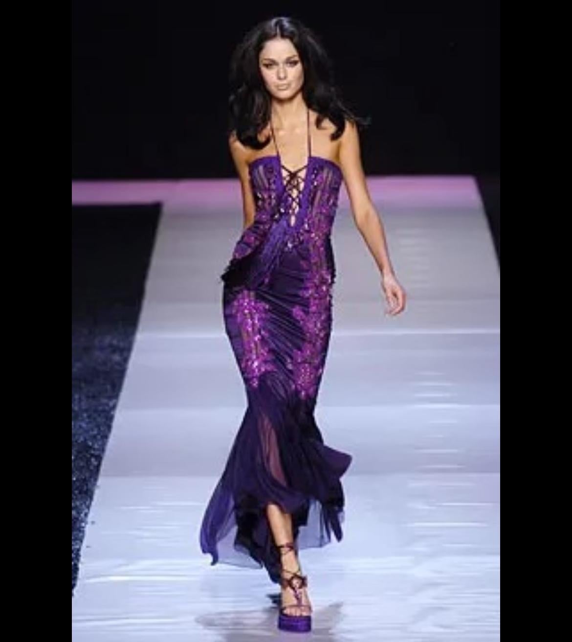 Elle présente une magnifique robe en satin violet d'Emanuel Ungaro conçue par Giambattista Valli. Issue de la collection printemps/été 2005, une version de cette robe a fait ses débuts sur le défilé de la saison en tant que Look 45, portée par