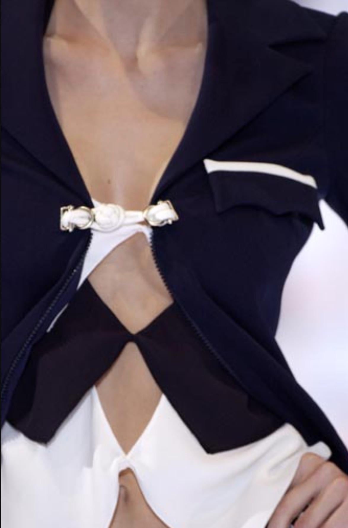 Issu de la collection printemps/été 2004 de Giorgio Armani, ce top en soie à étages associe des panneaux blanc cassé et bleu marine dans un motif géométrique saisissant. L'encolure dos nu se prolonge par un dos ouvert avec des liens fins qui
