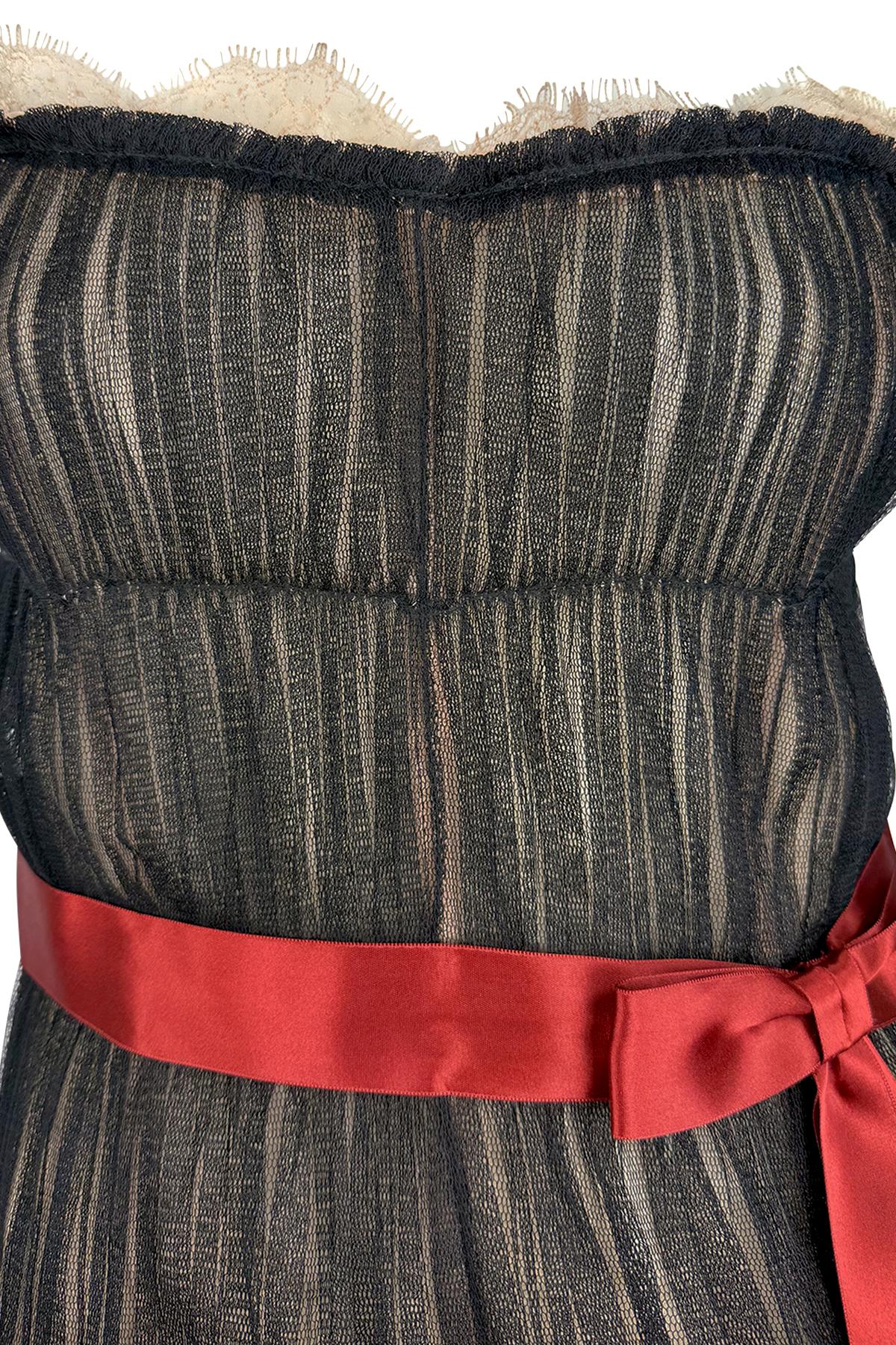 Dalla collezione primavera/estate 2006 di Dolce & Gabbana, questo top bustier in tulle nero trasparente è delicatamente steccato per garantire la struttura e presenta una struttura morbidamente pieghettata. La scollatura è ornata di pizzo color