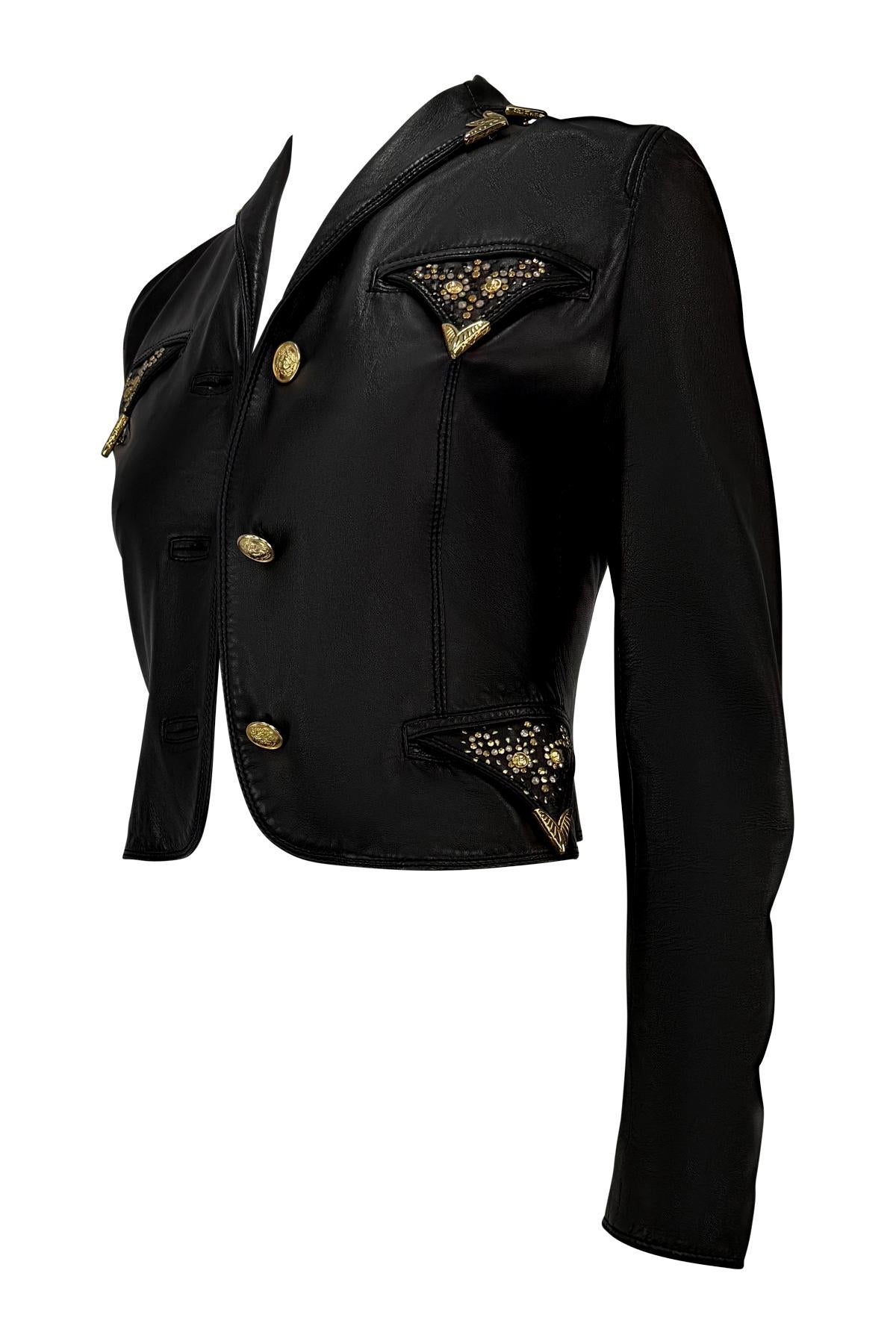 Aus der Herbst/Winter-Kollektion 1992 von Gianni Versace stammt diese schwarze, taillierte Lederjacke mit goldfarbenen Medusa-Knöpfen und den charakteristischen Nietenverzierungen, die in floralen Motiven angeordnet sind. Die scharfe Silhouette wird