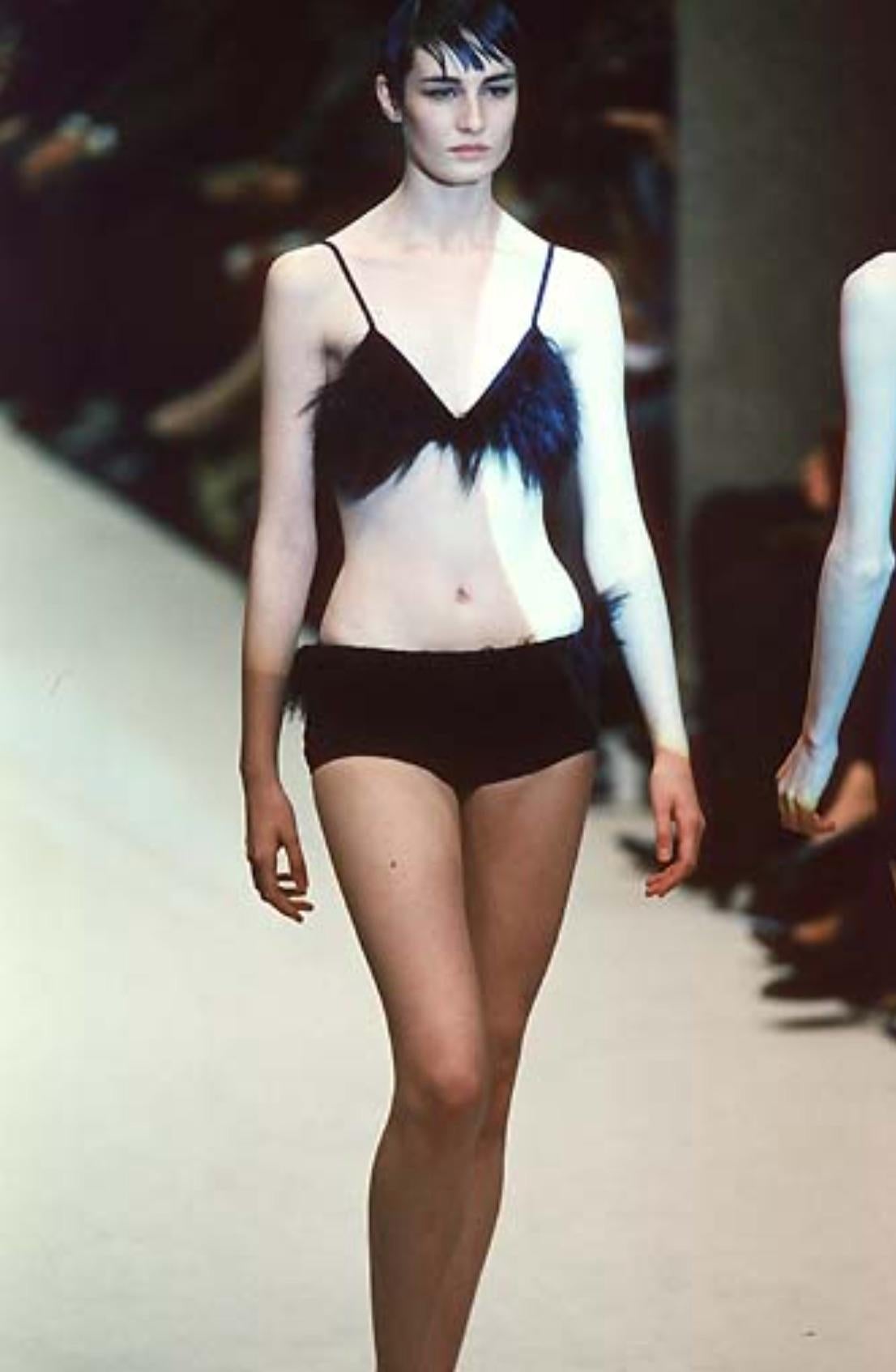 Dalla collezione primavera/estate 1998 di Karl Lagerfeld for Fendi, questo bikini nero è caratterizzato da vistose applicazioni in pelliccia nera lungo la scollatura e la fascia in vita. Una variante di questo design ha debuttato in passerella,