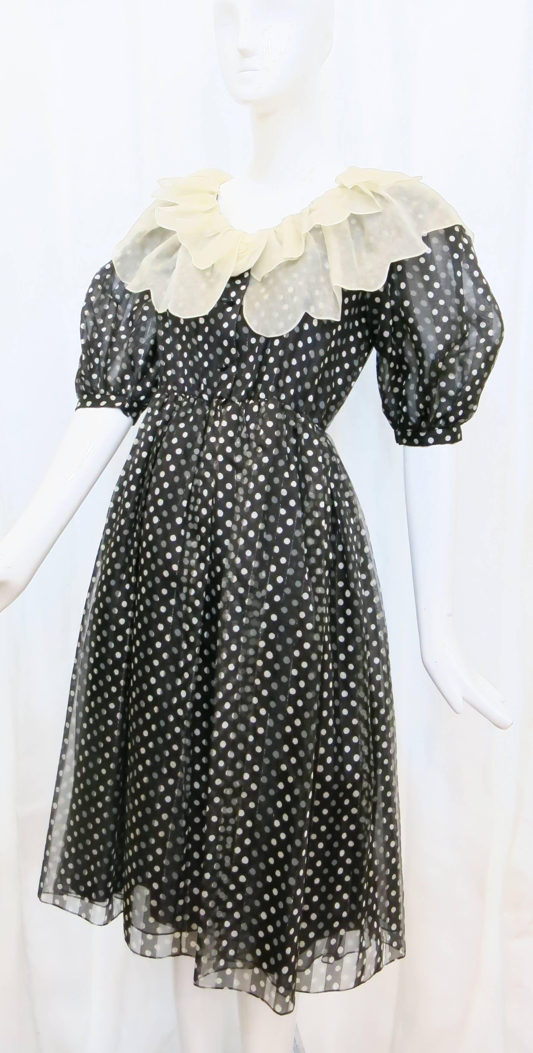 Black button down silk dress with scalloped collar and 1/2 sleeves. Sheer outer layer with solid black lining. Hits right below the knee. A perfect dress to wear to summertime weddings, cocktail parties or the office as it is airy and not too heavy.
