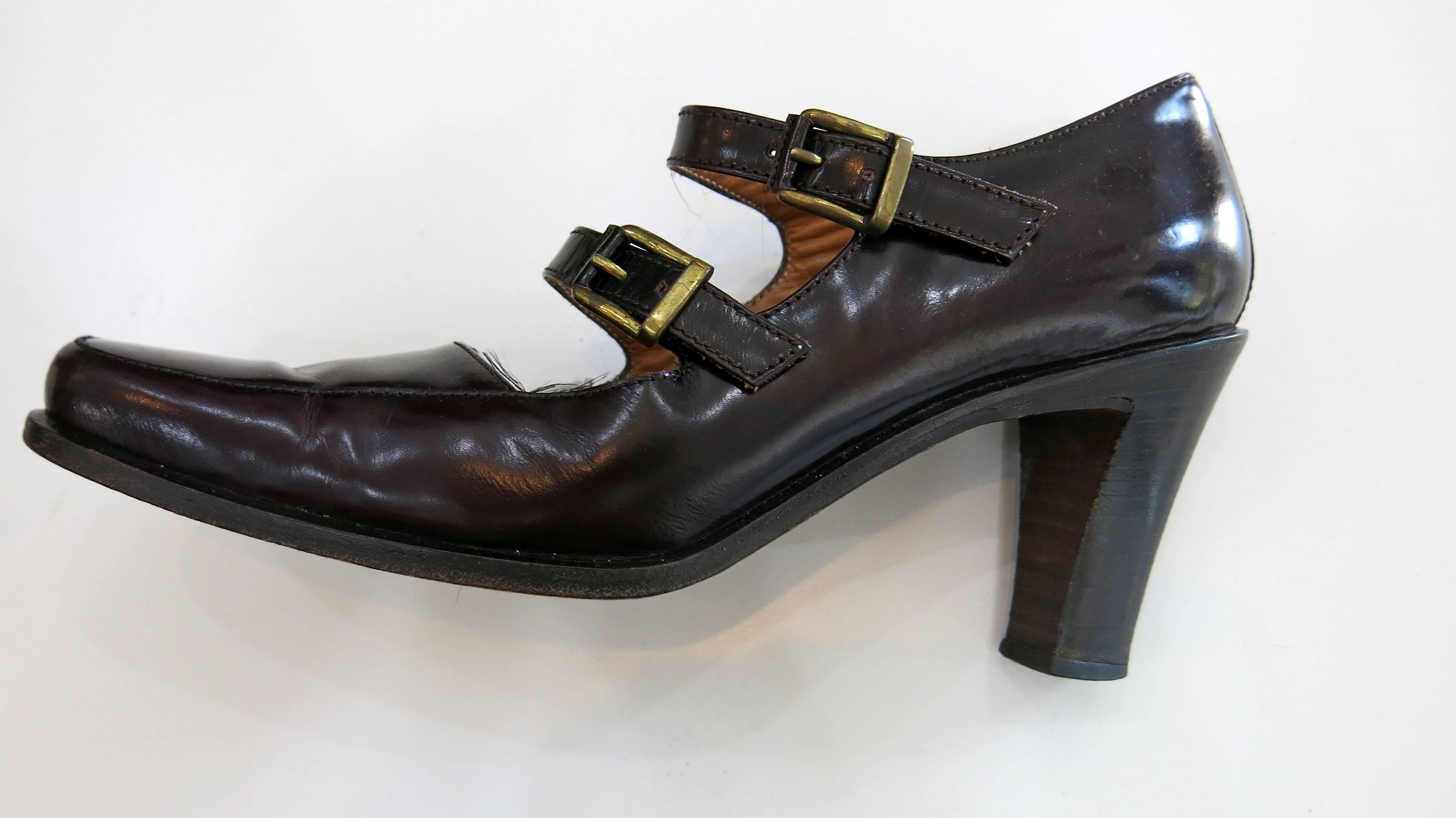 Dark reddish brown leather Mary Jane style heels with double buckled straps and a three inch heel. Some minimal creasing in the leather at the front of the shoe by the toes as a result of usage and age. Can be dressed up or down and will go with