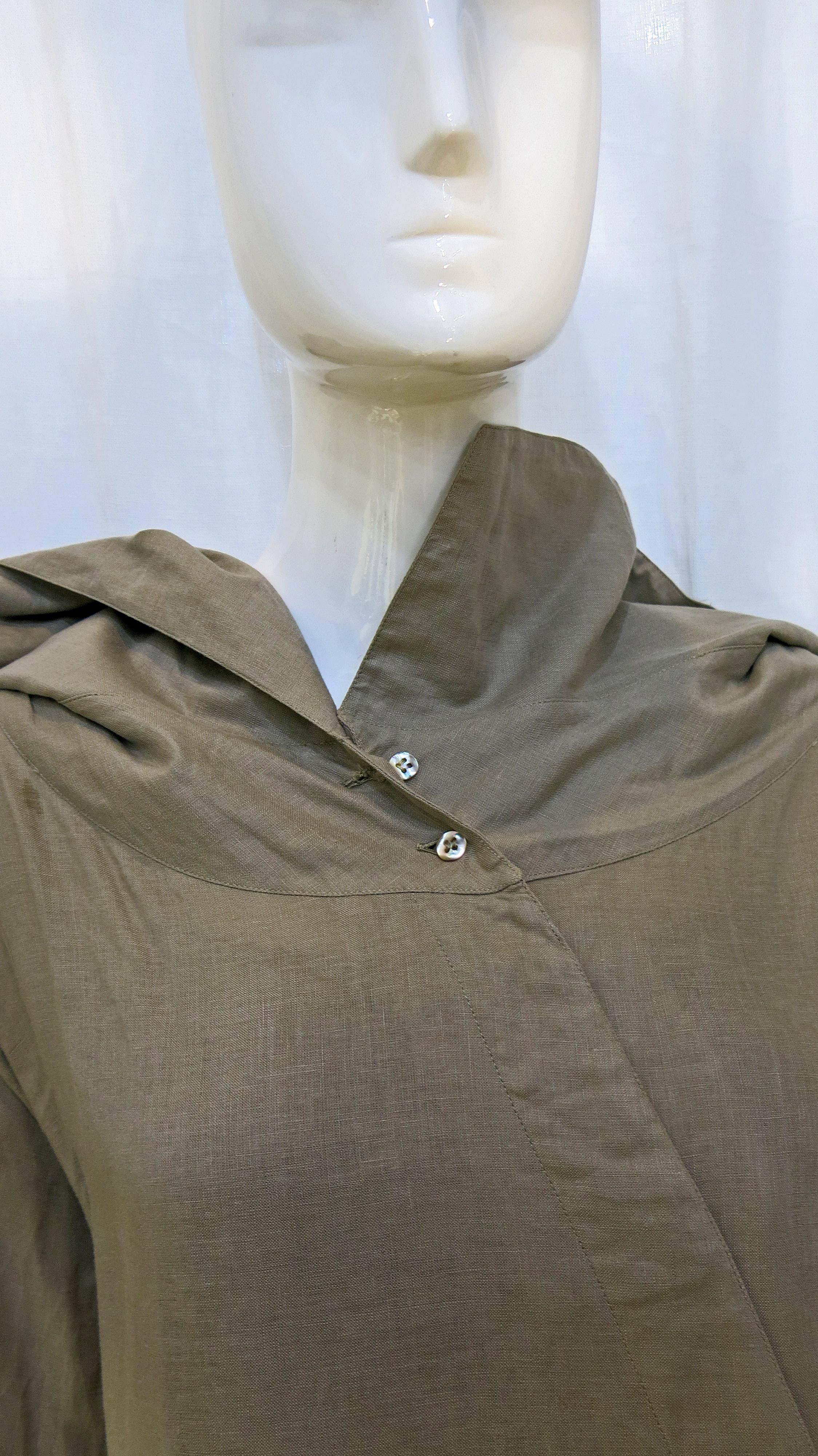 Gray linen blouse with asymmetric hidden buttons. Collar is oversized and also asymmetric with the right side being longer than the left. Long sleeved with four mother of pearl buttons at the cuff of each sleeve. Seam running down the back of the