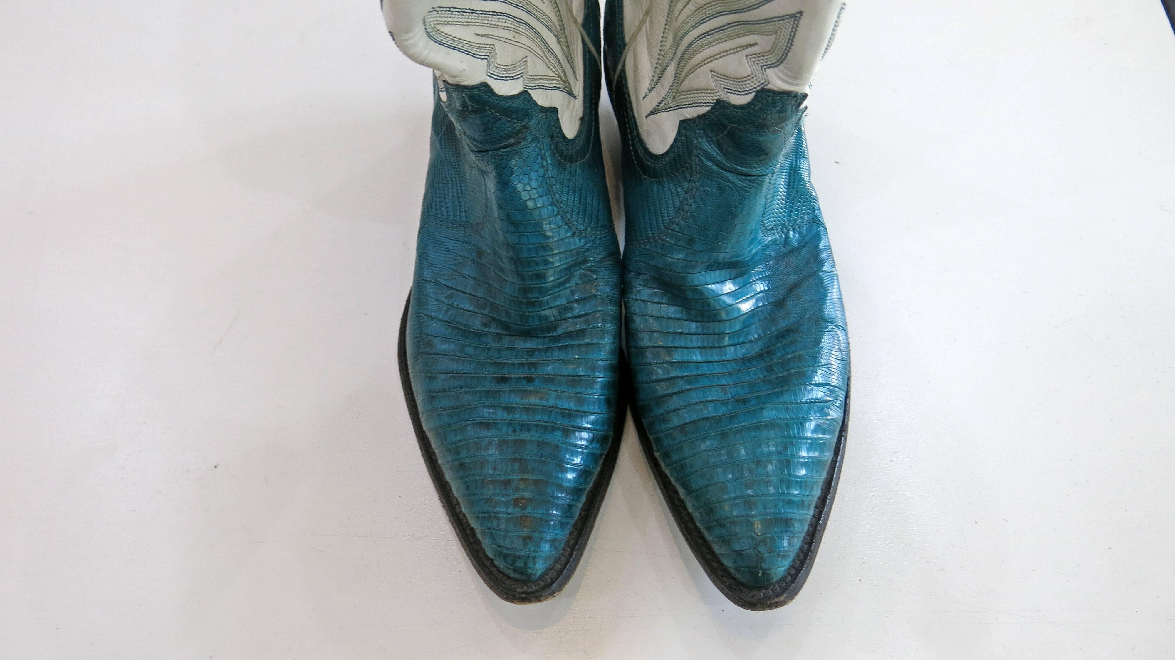 White and turquoise leather and snakeskin cowboy boots. Stitching on the upper part. White piping on either side of both boots. Nicely broken in and the soles are in great condition. Very well made boots. 4 inch opening for calves. 

Justin was one