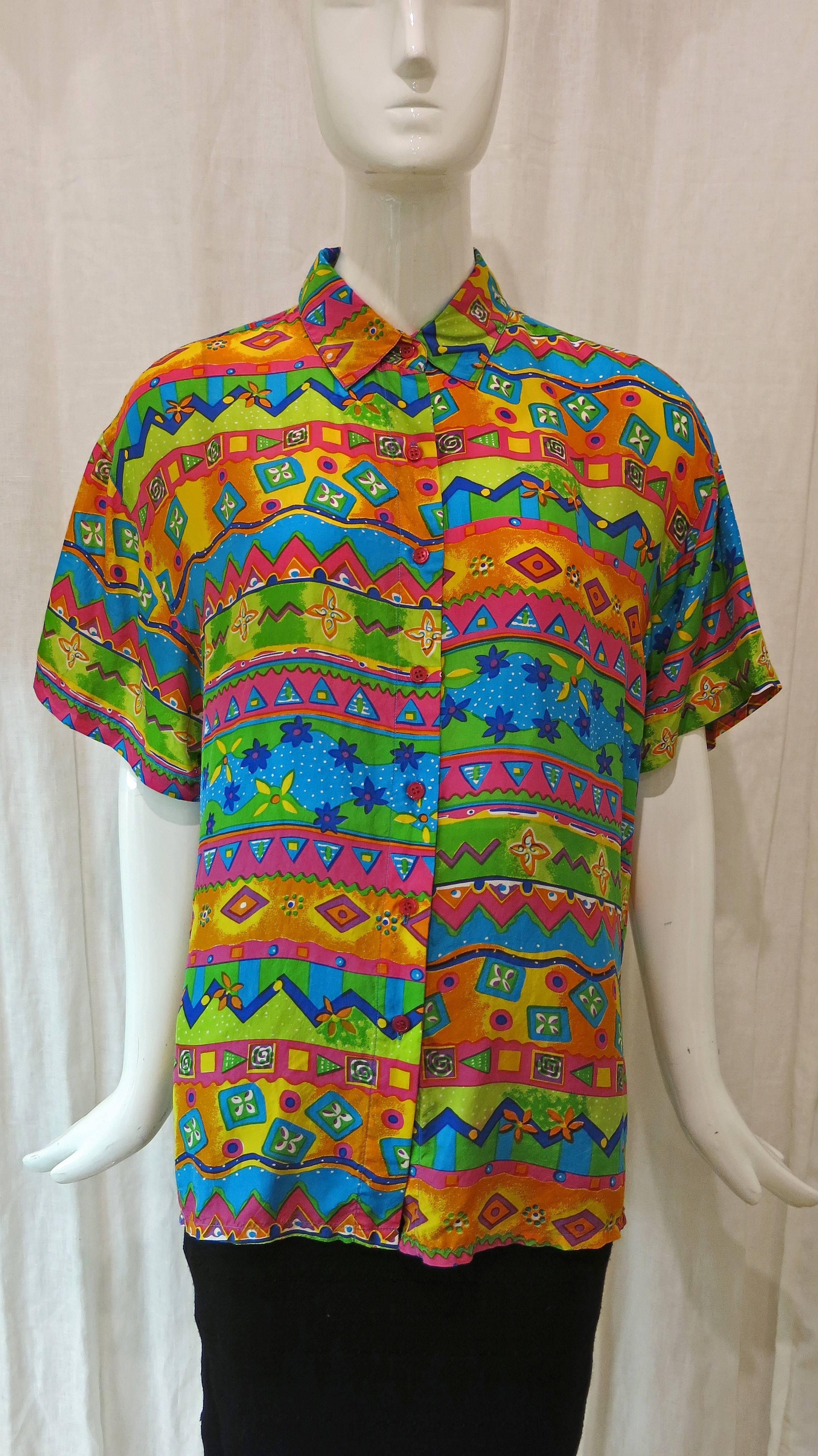 Vibrant patterned short sleeve button down blouse. Collared and made of silk this eye catching piece will brighten up your wardrobe. 

Known best for his beautifully crafted gowns and formalwear, Oscar de la Renta had a long and illustrious career.