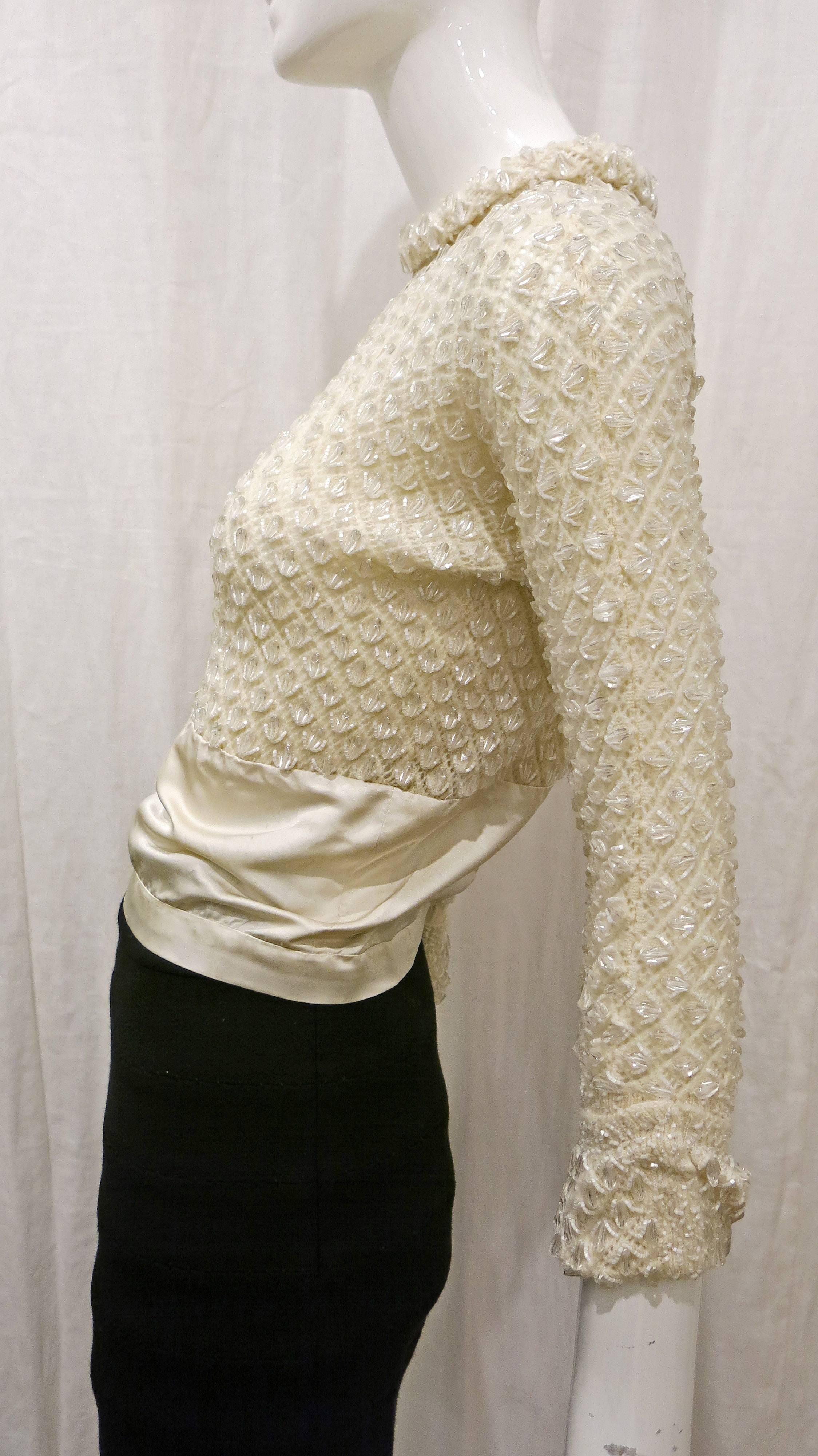 1960's Cream colored knit sweater with allover beaded detail. Rolled collar and cuffed sleeves. Silk on lower half of torso as well as inside of cuffs. Eyelet. Zips down back of garment. No tags, most likely homemade. 