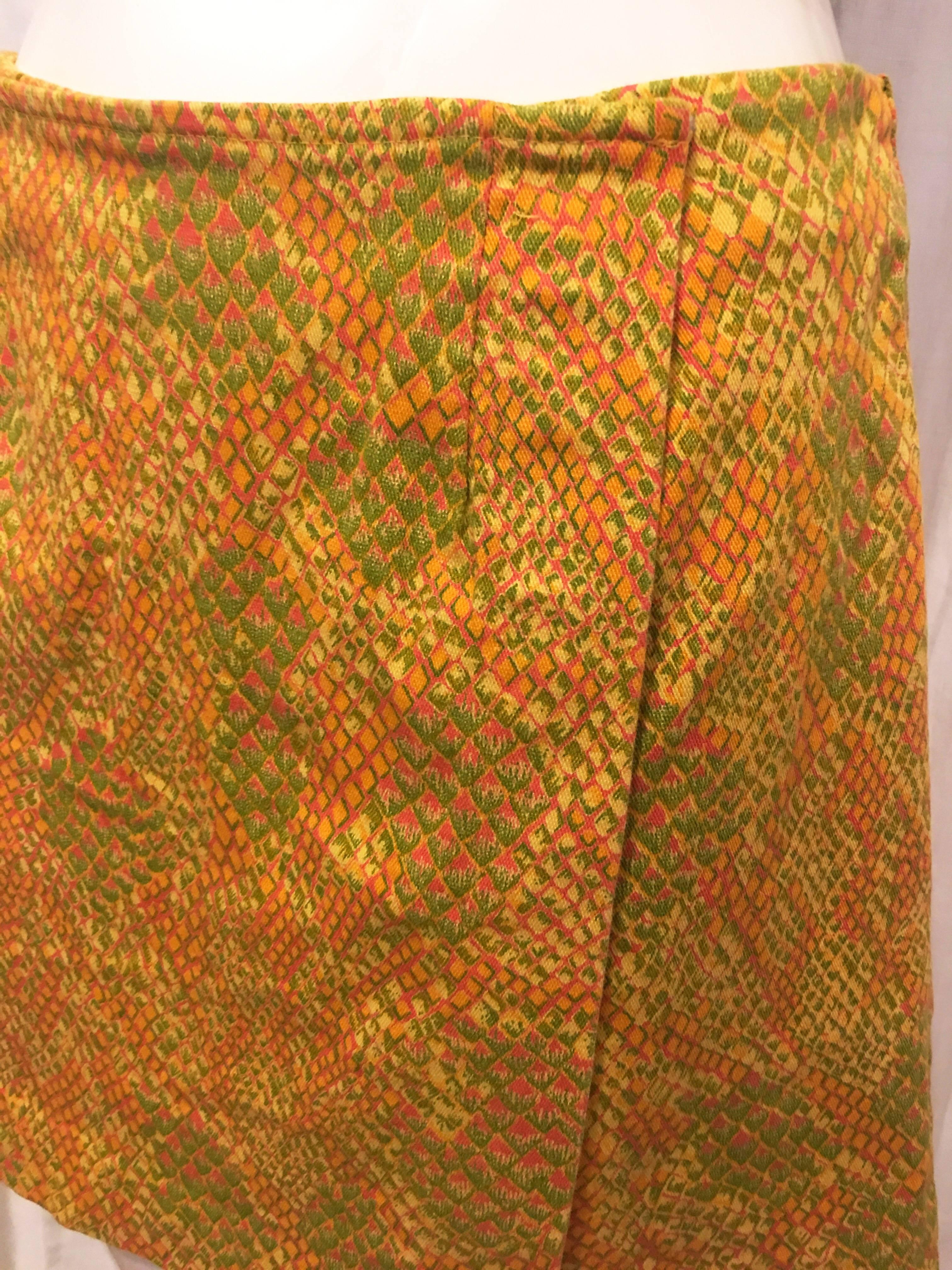 Snakeskin style print in red orange yellow and green. Snap button closure connects flap of skirt over front of shorts. Shorts also zip up back. Hit at about halfway down the thigh. 