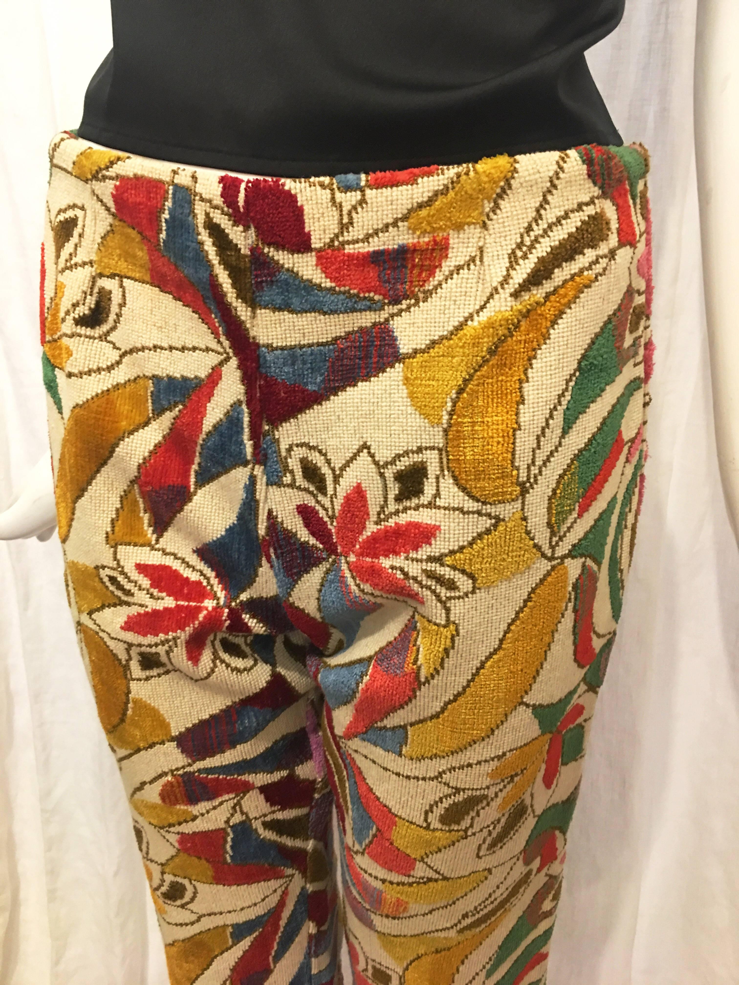 White pants with all over multicolored floral print. Zip up the back with hook and eye closure. Flared at bottom. Slight rip at seam-please note photos. No tags, most likely handmade. Sit on the hips. A bold pair of pants for those who aren’t afraid