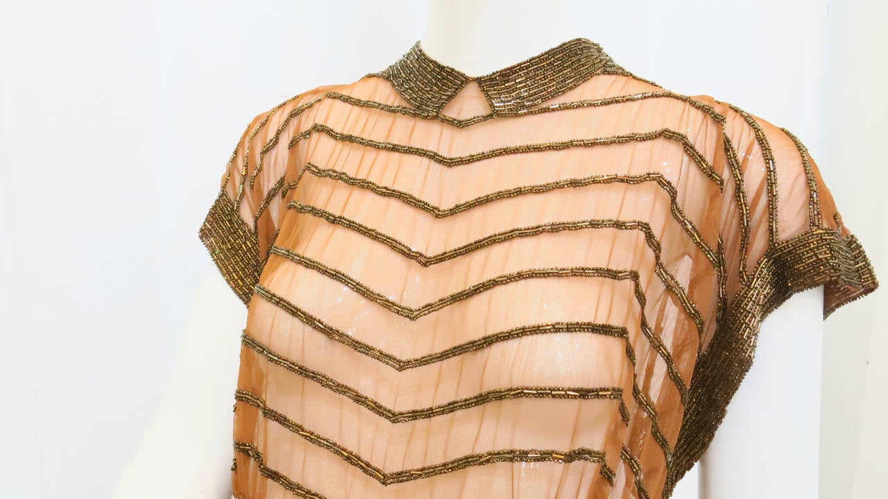 This opulent copper mesh beaded top embodies all of the experimentation with fashioning the body that was explored in the 1930s. A break from Victorian-era modesty and an obligatory departure from early 20th century corsetry, this revealing top