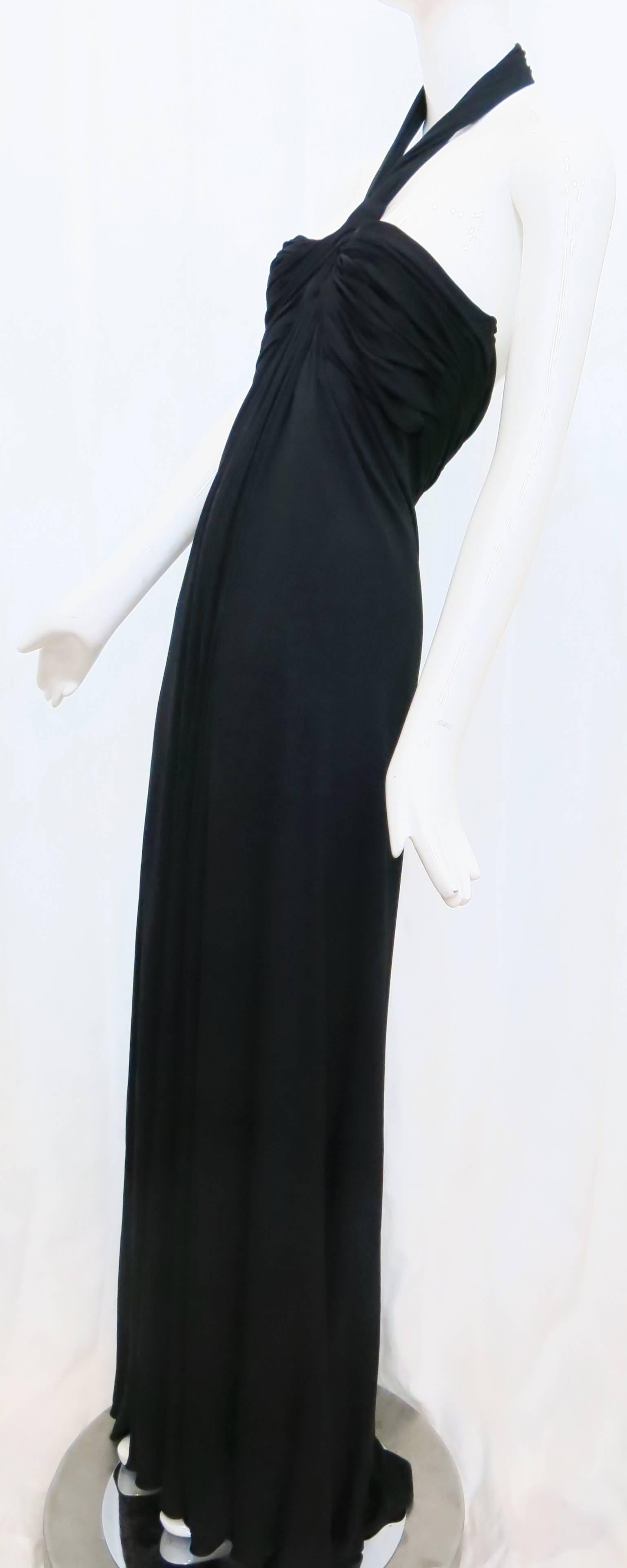 This crêpe Georgette halter gown designed by Bill Tice for Malcolm Starr embodies a classical Grecian influence and the thrill of garments that move with the body in the 1970s. Features an empire waist and a halter that fastens through hook-and-eye