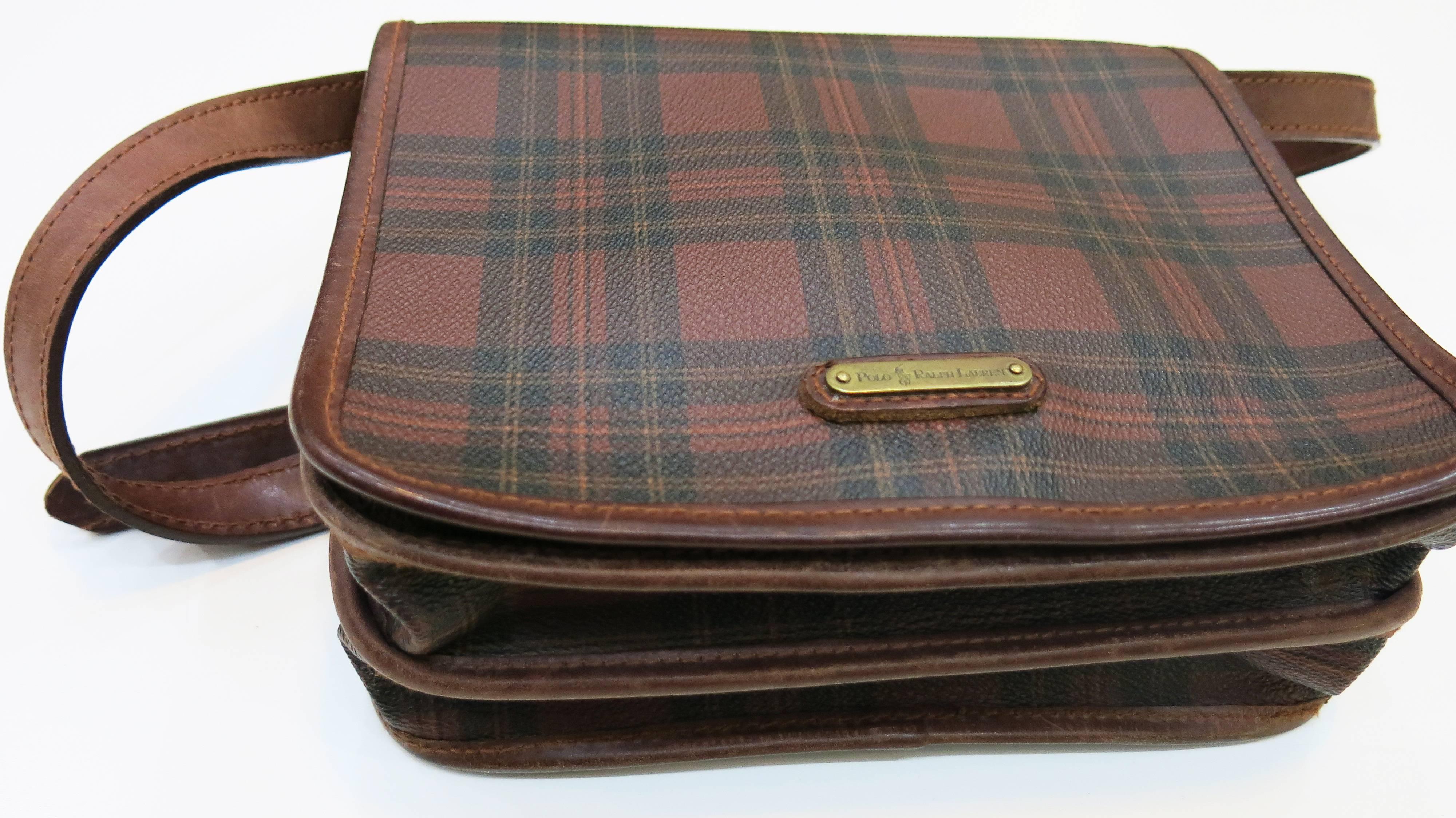 Leather satchel-style plaid shoulder bag with adjustable leather strap and canvas lining. Two open inner pockets one zip pocket. The perfect size for carrying everything you need without over-stuffing.

Leather has average wear for the bag's