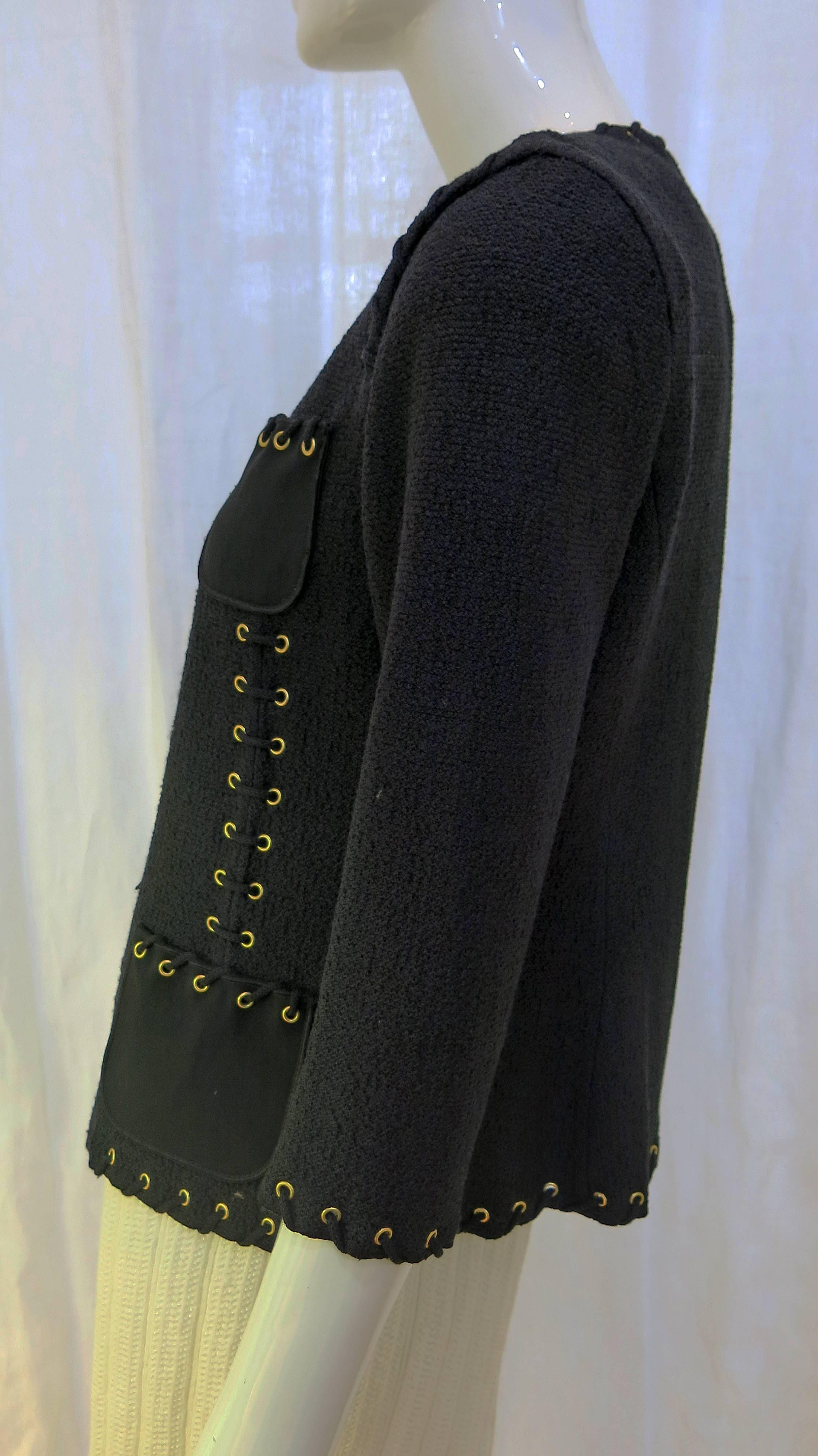 3/4 length sleeve blazer with embellished trim in the form of gold-toned eyelets with laces weaving through. The jacket is made in the signature St. John wool Santana knit style. It features 4 silk pockets on the front as well as silk inner lining.