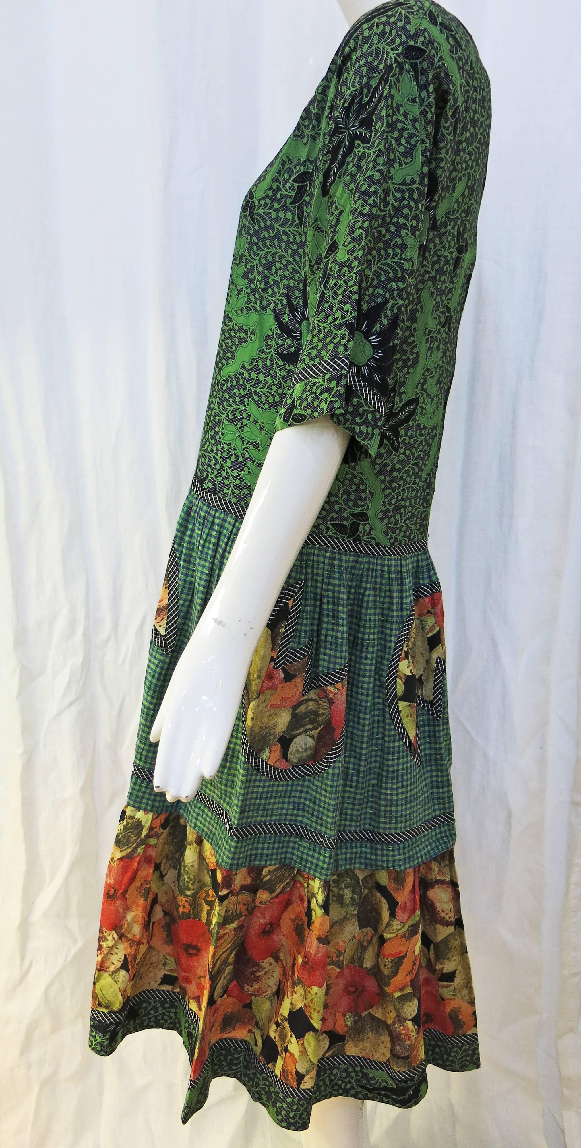 1/2 sleeve lightweight cotton spring dress with the signature Koos mismatching of patterns and colors. The dress features a green/black floral pattern on the bodice with a pink/beige floral yoke. Both patterns are also featured on the hips and