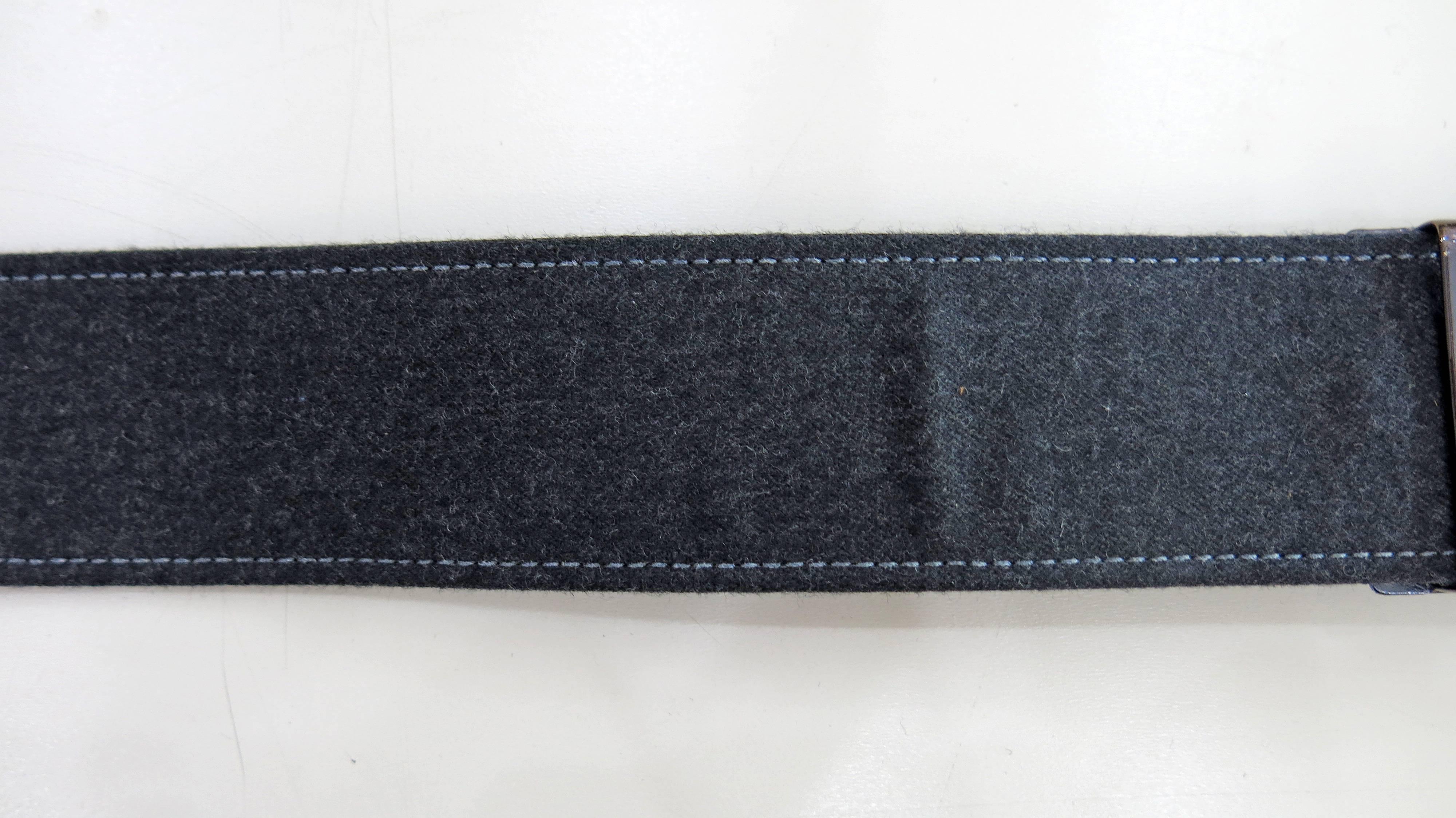 Dark gray wool belt with metal buckles and hardware. Leather on the underside. Gray stitching. Stamped with the Oscar de la Renta logo. 30 inches in length and 1.5 inches in width. 

Originally a painter, Oscar de la Renta began his fashion career