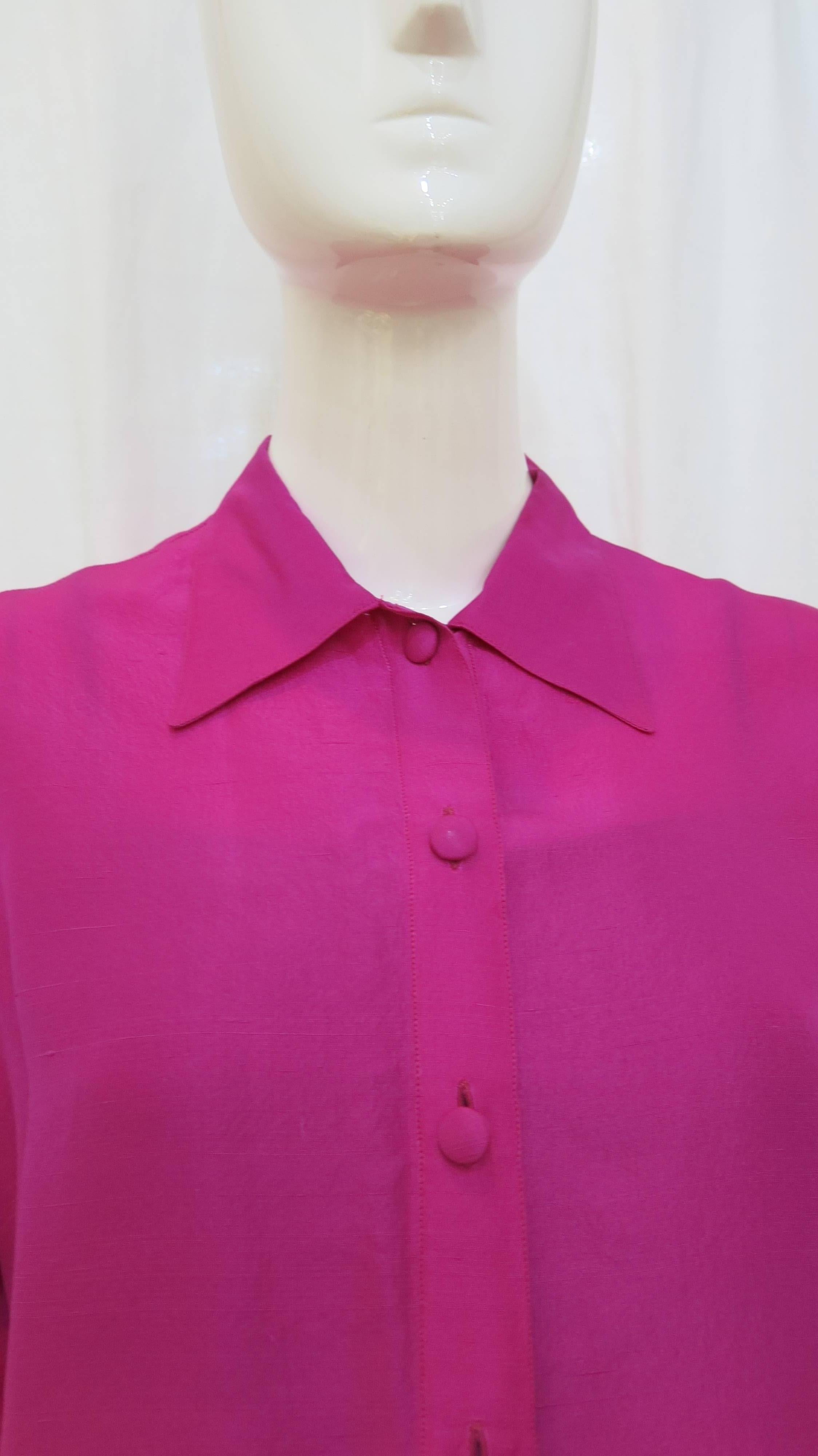 Vibrant pink button down silk blouse from favorite Patrick Kelly. Six button closure at the front of the garment. Nonconventional cuffs on the sleeves with invisible seam and cut outs where normally there would be buttons. A great staple piece to