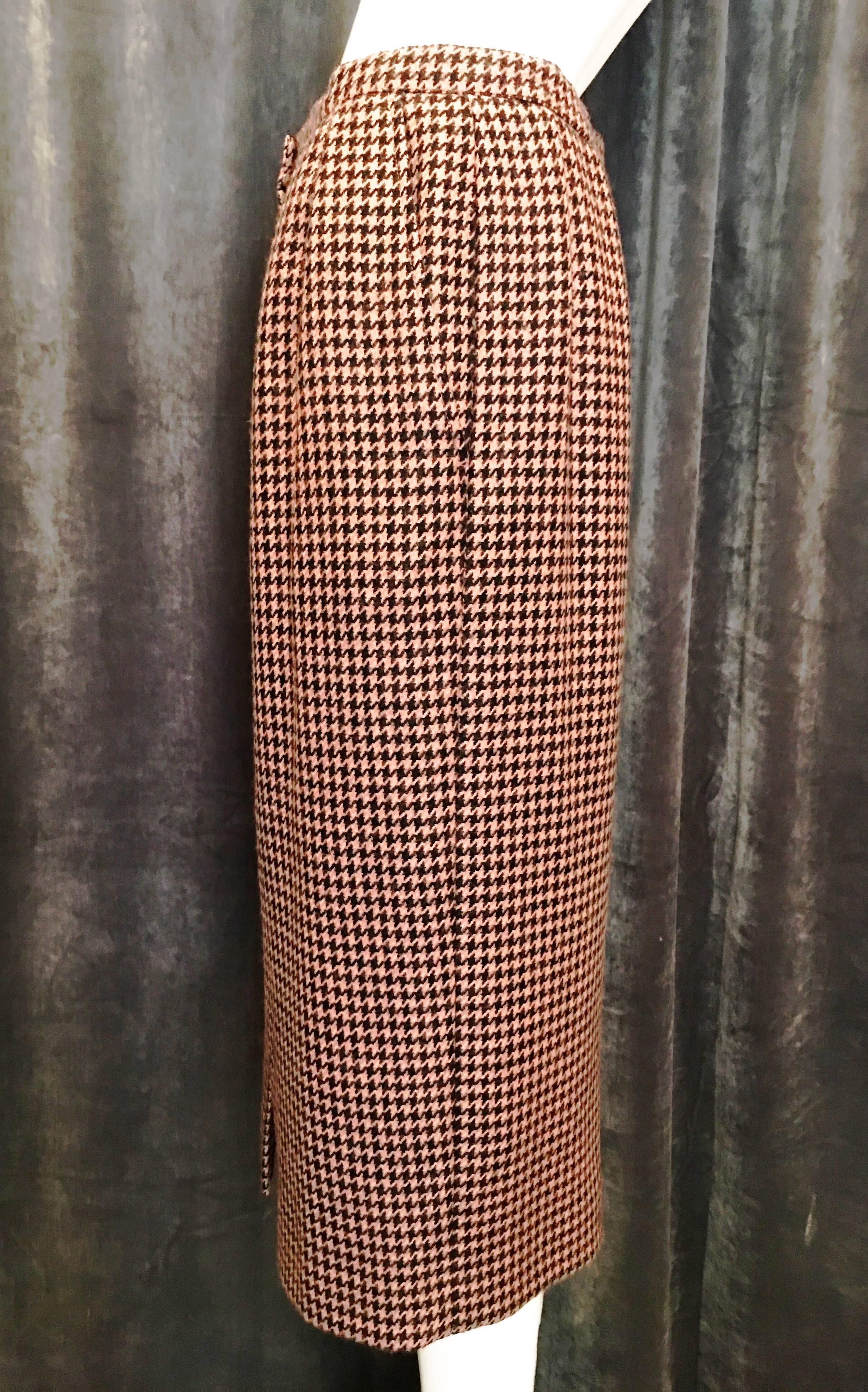 Pink and black houndstooth pencil skirt in weighty wool. Seven black buttons down the front. Two front pockets. Fully lined. Simple and flattering, sure to become a staple piece in your wardrobe. Matching cropped jacket also listed on our 1st Dibs