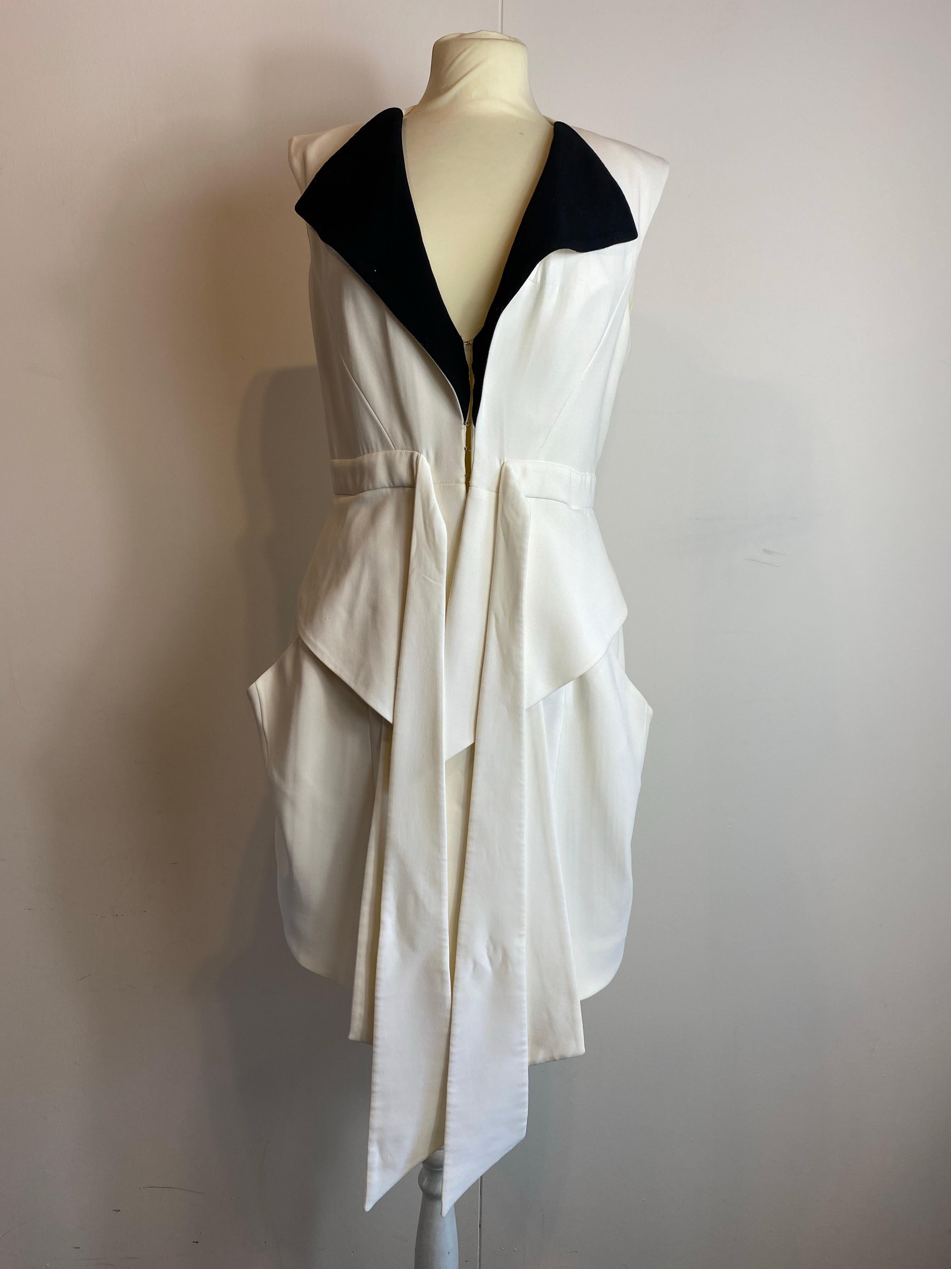 Robe midi blanche à détails noirs de Givenchy. Printemps  2010
Convient à un IT 38-40.
Épaules 38 cm.
Longueur 95 cm.
Label de composition non présent, il semble être en soie.
Excellent état, présente de légers défauts comme indiqué sur les photos.