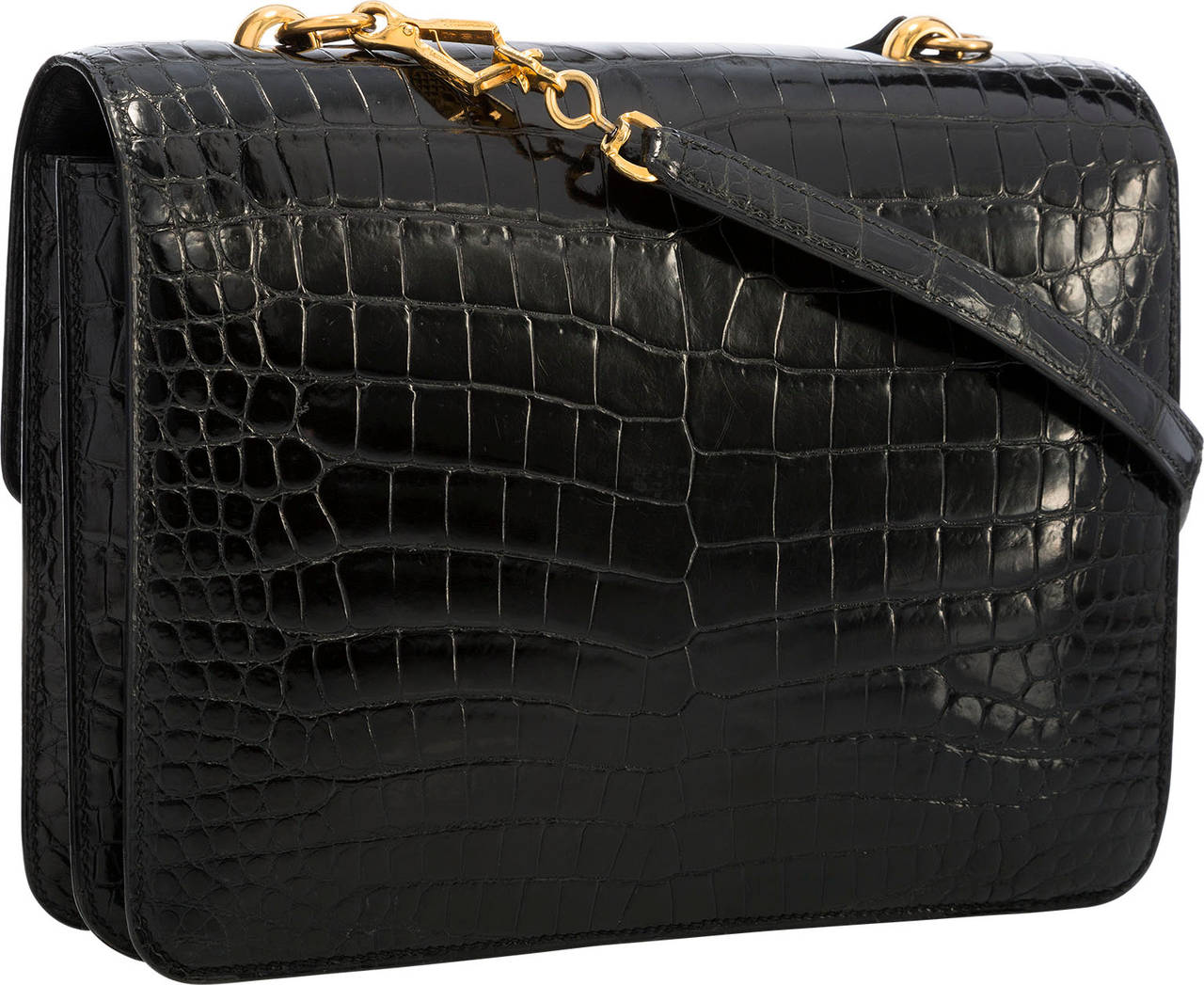 This timeless shoulder bag is sure to be a favorite of any Hermès enthusiast. Done in Shiny Black Porosus Crocodile with Gold Hardware, this bag is classic, yet not often seen. It features a flap top with a tuck closure. The interior is done in