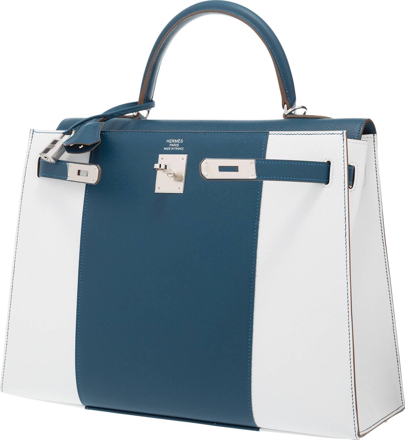 This bag is gorgeous. The exterior is done in Blue Thalassa and White Epsom Leather with Palladium hardware. The interior is done in Blue Thalassa chevre leather with two slip and one zip pockets. This bag comes with a shoulder strap, lock, keys and