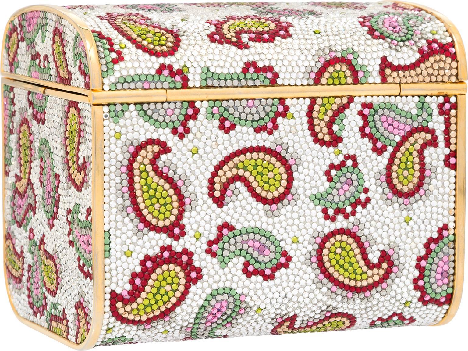 This colorful paisley trunk is a great way to sport exotic travel style in a fabulous fashion. Created with the jetsetting socialite in mind, with a beautiful array of green, pink, red, gold, and silver crystals. This bag is trimmed in gold tone