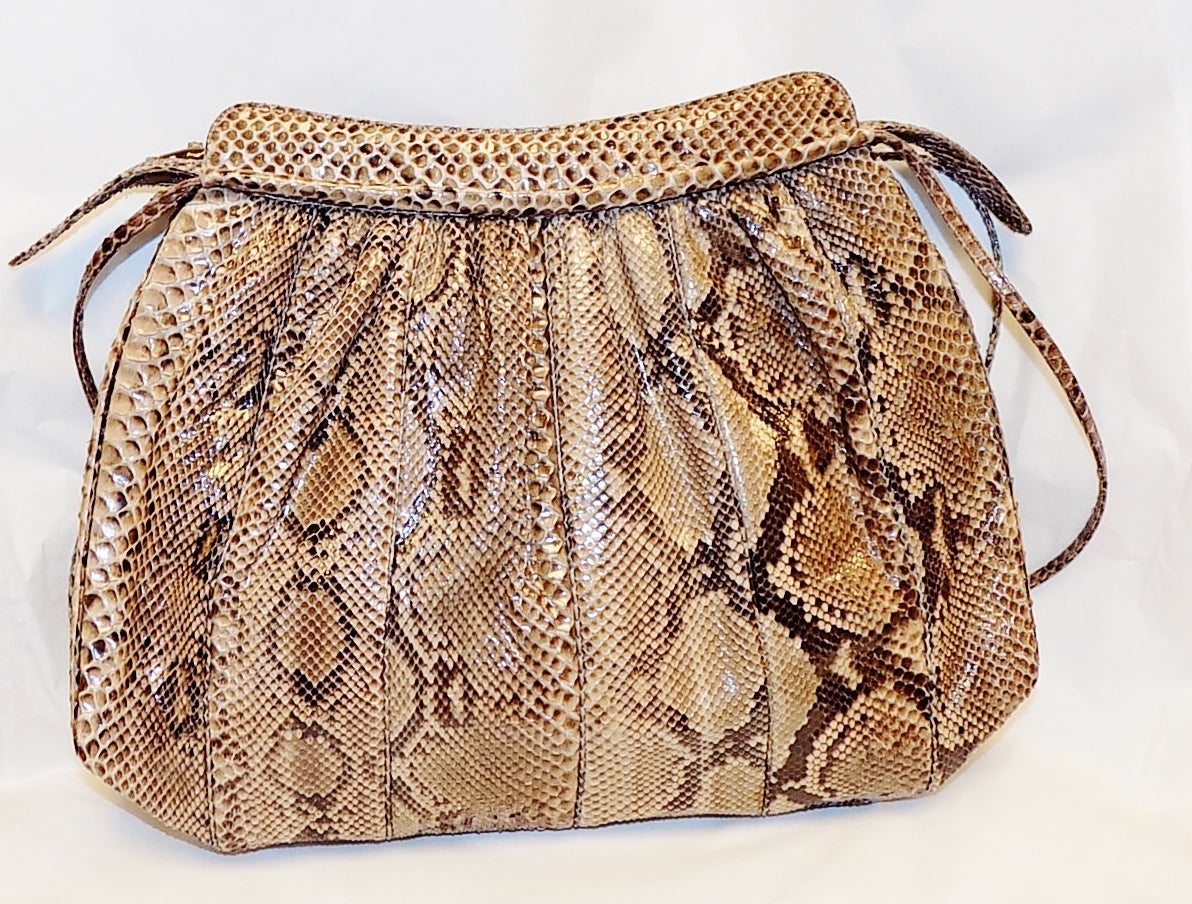 Very beautiful large natural color exotic skin/  cobra snake bag. Simple design with soft  side and Zipper top closure allows you to store plenty of items. This bag is all leather lined and in pristine condition.
Two  thin shoulder strap could be