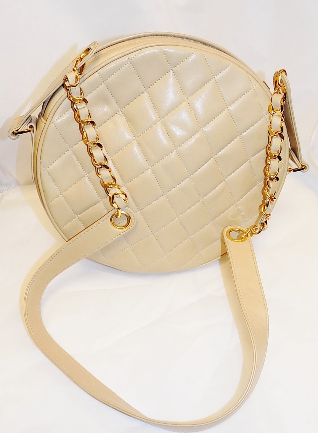 Add a bit of funk to your wardrobe with this fun Vintage Chanel round bag--perfect for all seasons?! This bag features Chanel signature quilt in supple lamb  skin leather , leather lined, leather handle with gold chain detailing, zipper pull with