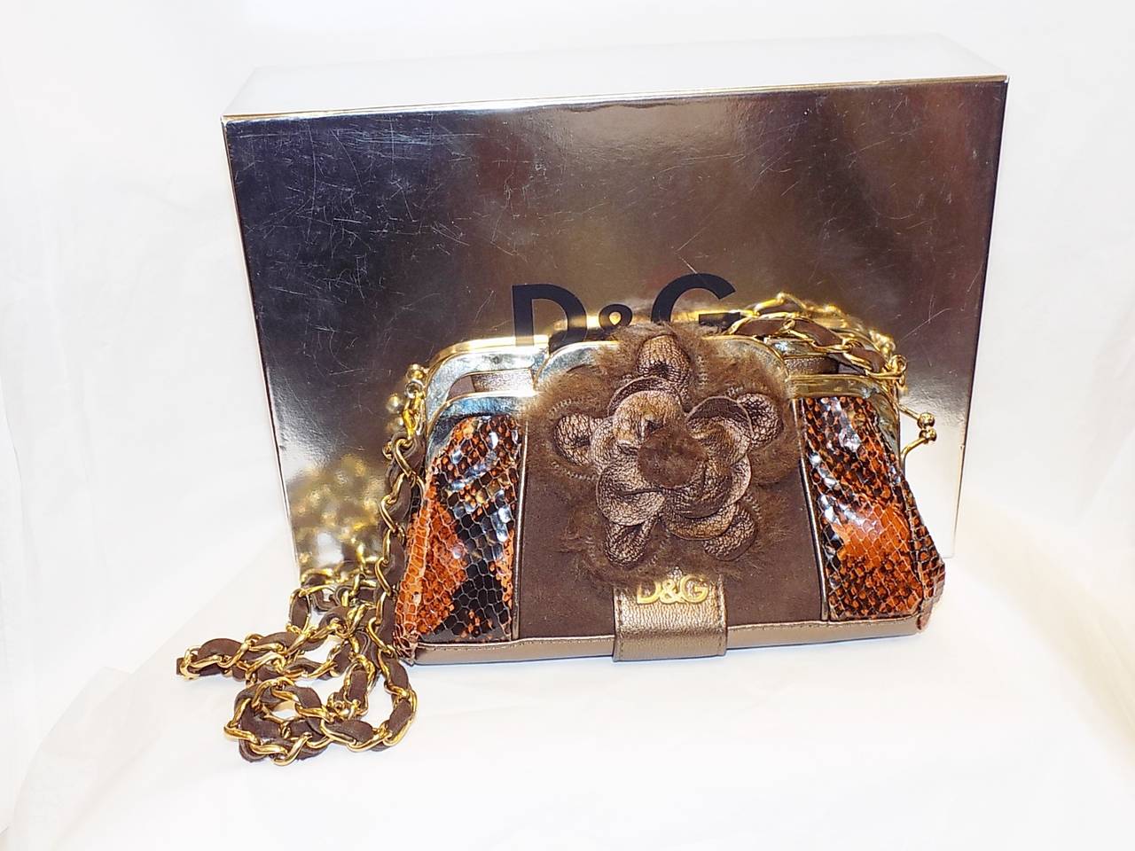Never used very rare fabulous  D&G Dolce & Gabbana  versatile bag.  Cobrad snake skin with metallic leather and suede with gold toned hard top frame. . Removable long suede and metal cross body length chain. Back of the bag features belt loop.