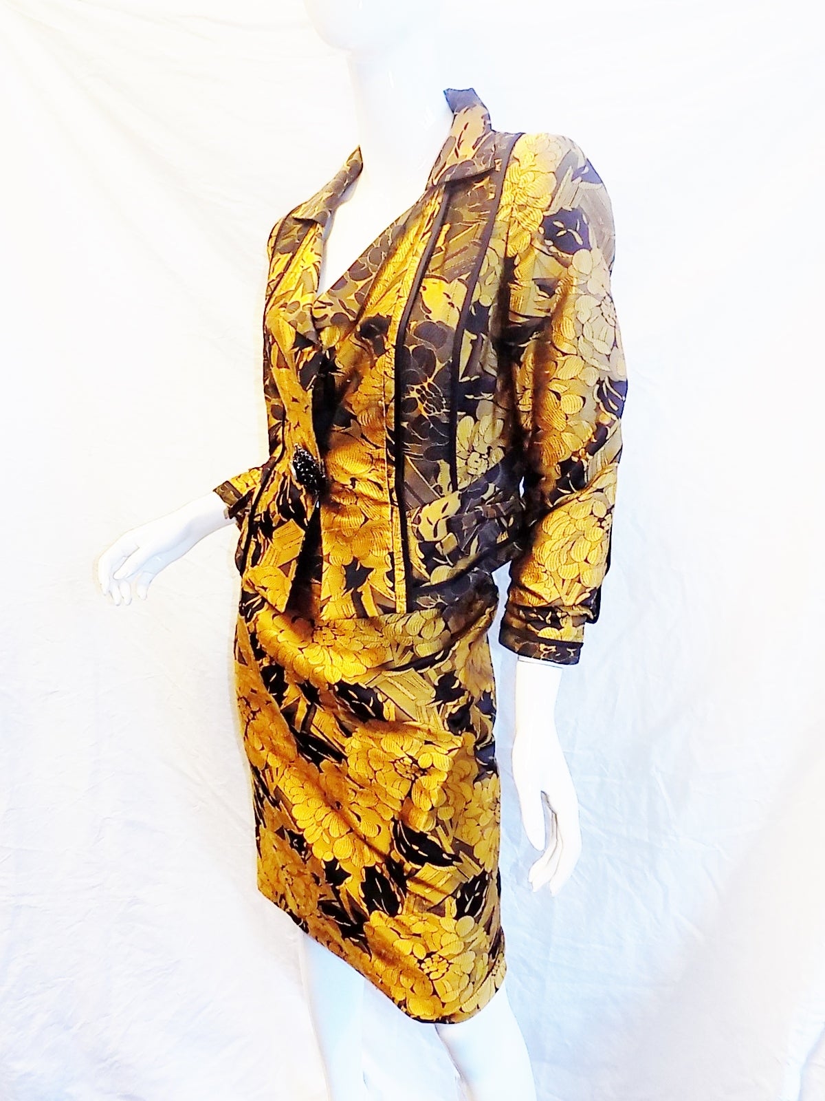gold and black silk brocade  skirt suit by Christian Lacriox. Incredible detailling from hand stitcing to small bows to the silk printed lining. . Front snap closure with stunning black CZ large hand set pin. Size 42 us 8
Pristine condition like