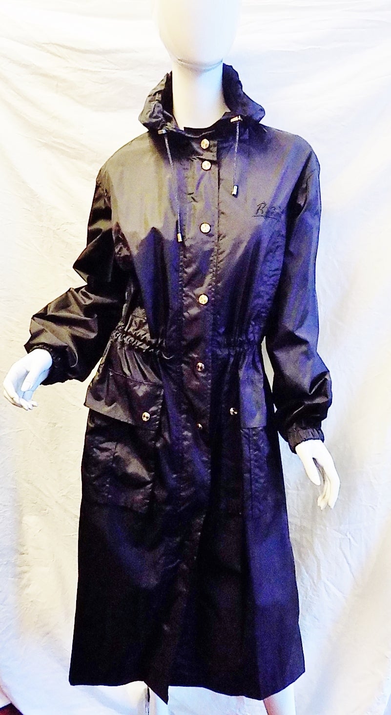 SONIA RYKIEL amazing  vintage black hooded rain coat. Features zip front with extra safety silver tone engraved  snaps. Adjustable drawstring  waistline . One large  flap pocket and two side top pockets. .Back fold. Grommet vents under arms.