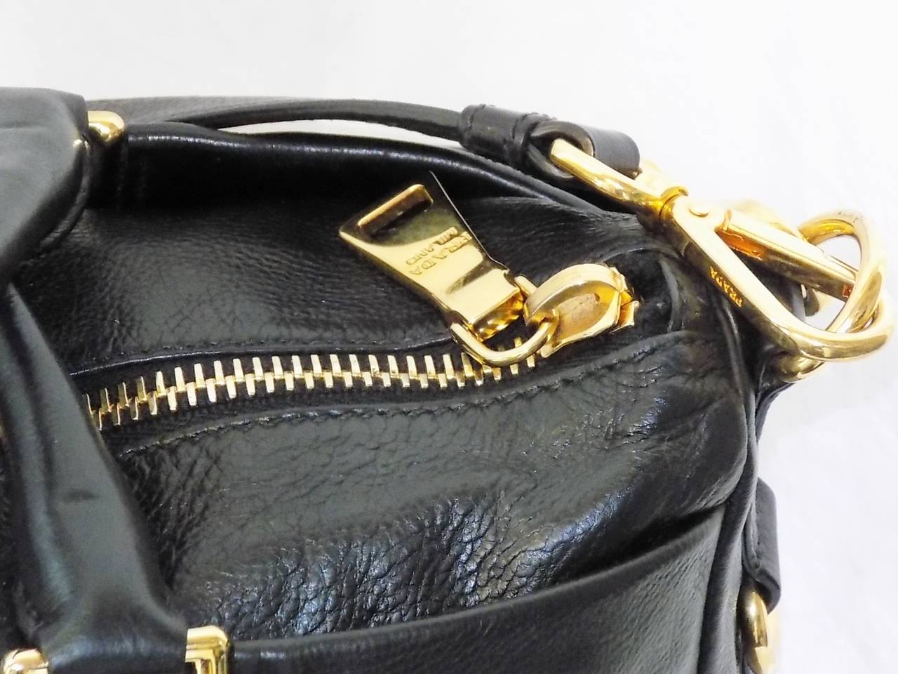 This is a must have baby soft leather large PRADA Executive Black Tote Bag . Featuring two outside pockets  with snap closures, top zipper closure and adjustable- removable shoulder strap and gold tone hardware. 
Perfect business bag for woman that