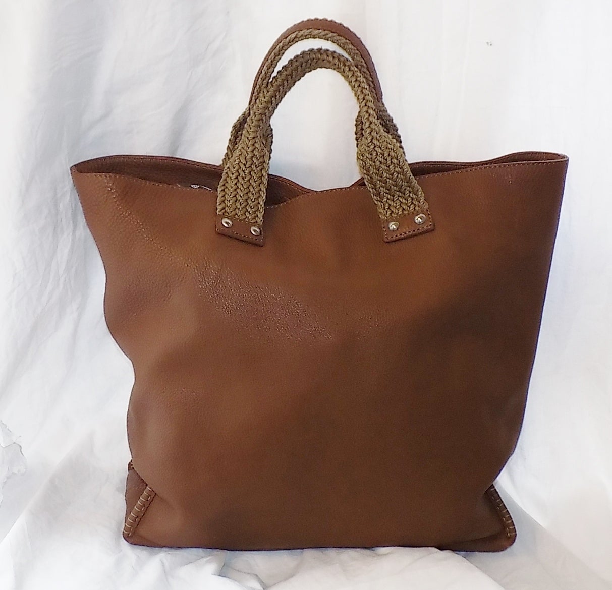 Perfect large tote from Fendi!  Pebbled leather. Fendi insignia on one side of the bag.   Woven handles reinforced with leather.  Fabulous design.  Hand stitched and reinforced edges of the bag. protective bottom feed  with Fendi logo. . Linen