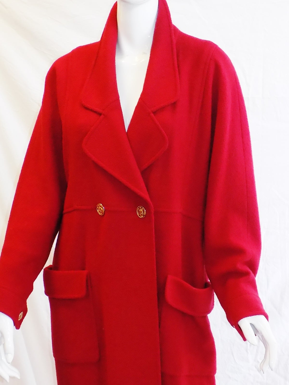 Spectacular  red Chanel coat. Pristine condition wool crepe entirely lined in cc logo silk. 
Coat features double breasted front closure with large Chanel crest engraved gold tone buttons, two large patch pockets and row of buttons at the back .