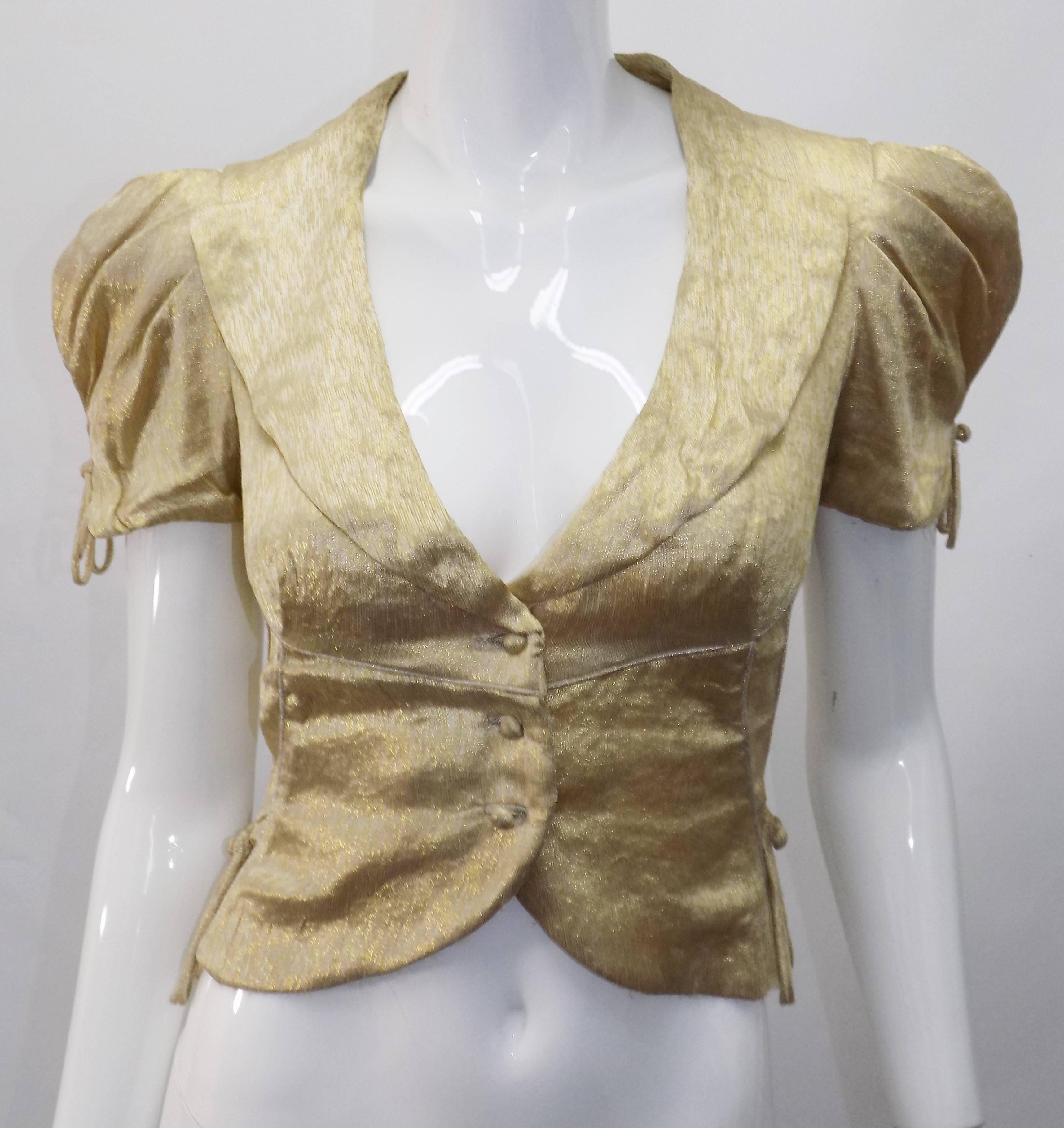 Fabulous  Louis Vuitton Gold Metallic Top. Wait line at the back is adorned with round ribbon fringe resembling military style. Short buffoon sleeves. Front covered buttons closure. Size 2. Great look paired with Jeans. 

Bust 34