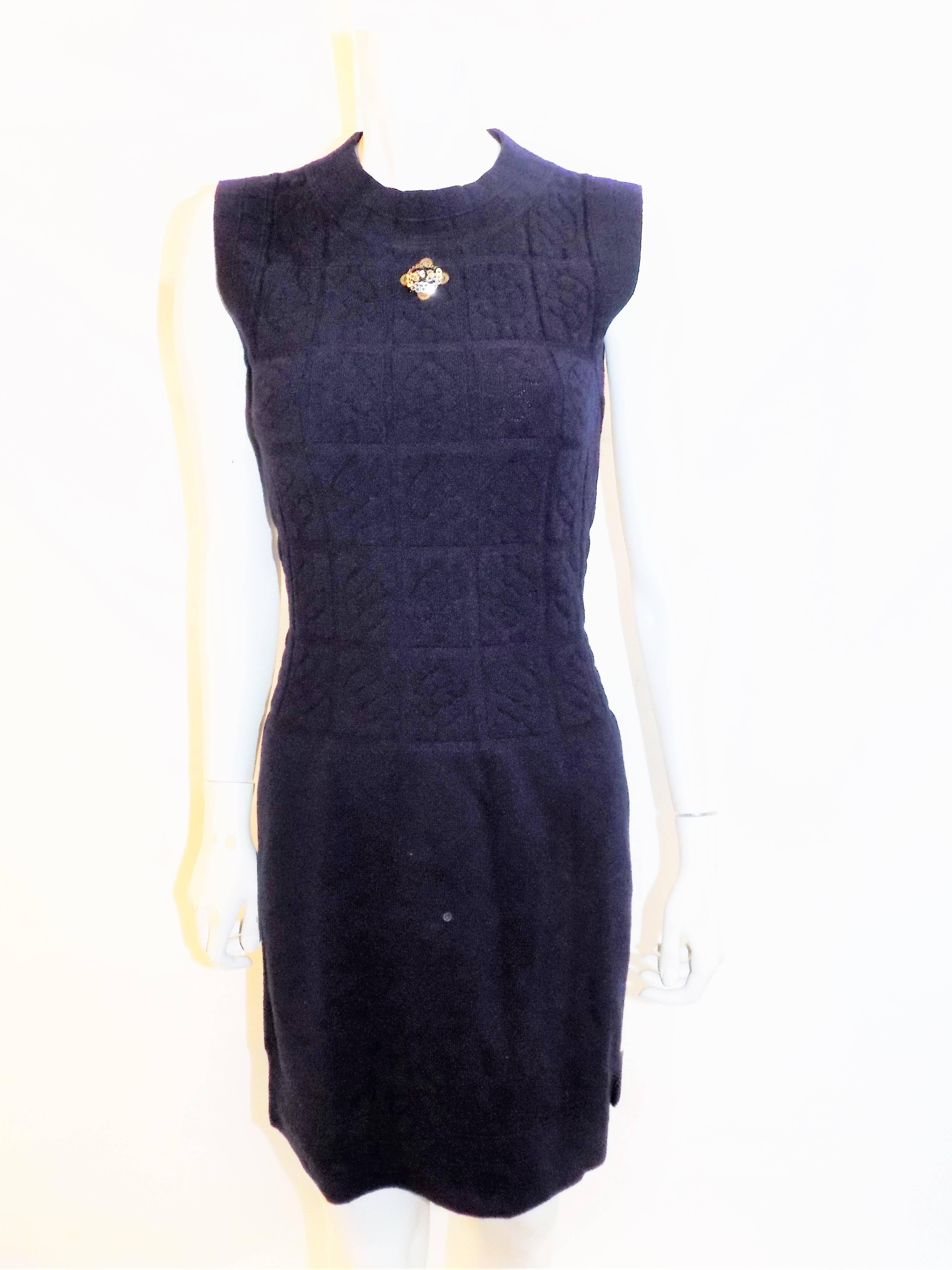 Fabulous and unique dark navy sleeveless dress and jacket set  by Chanel. Wool and cashmere blend., Raised /quilted style knit. Antique gold  ribbon trim  and stunning cc logo  Lesage patch at the front of the dress and the back of the jacket.