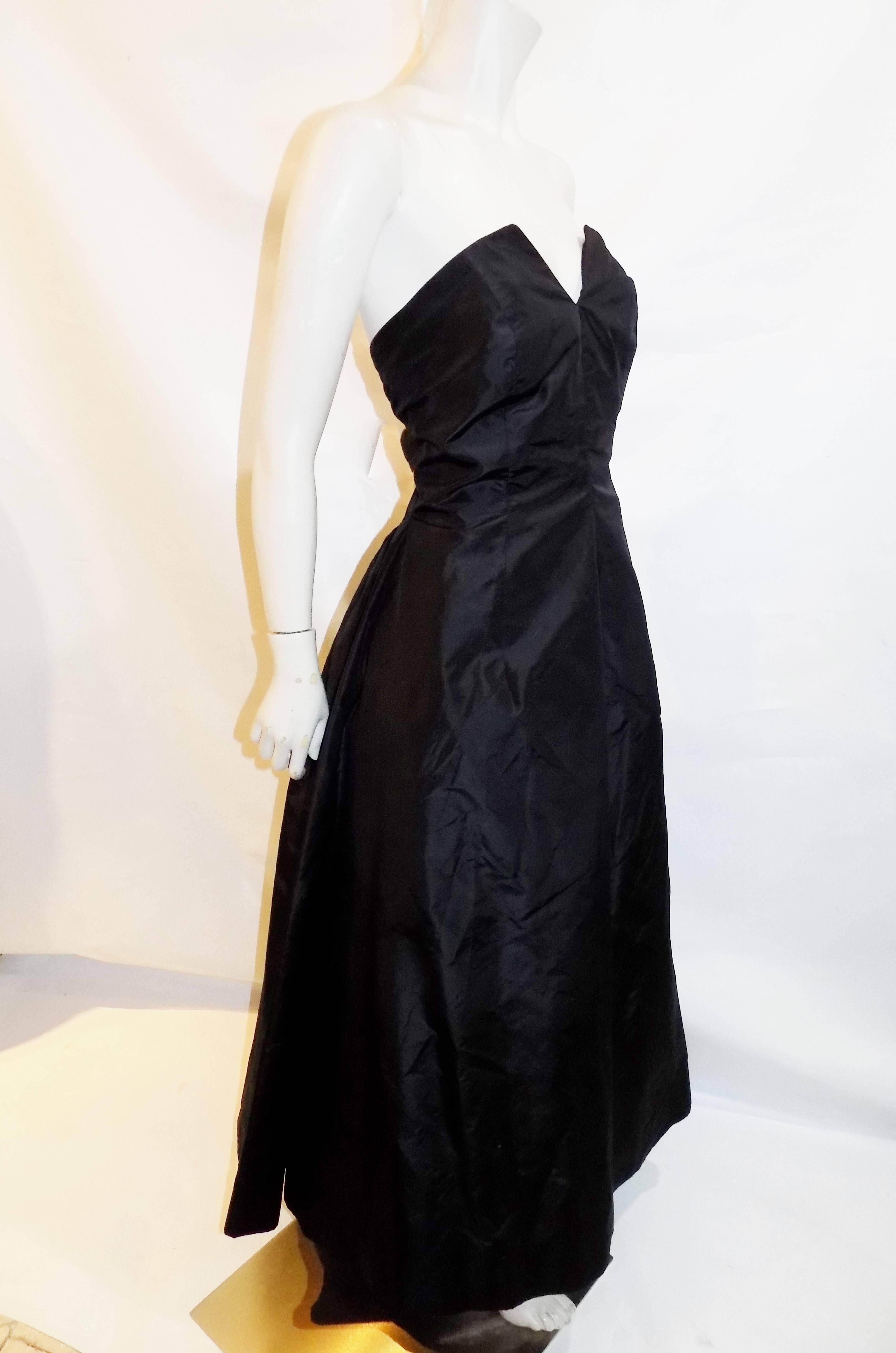 Vintage Oscar de la Renta strapless evening gown. 
Very 50's look, strapless corset V cut in the front. Gathered back of skirt, separate petty coat with a horse hair hem, pristine condition  
Black silk taffetta

Tag Size states 12 but please