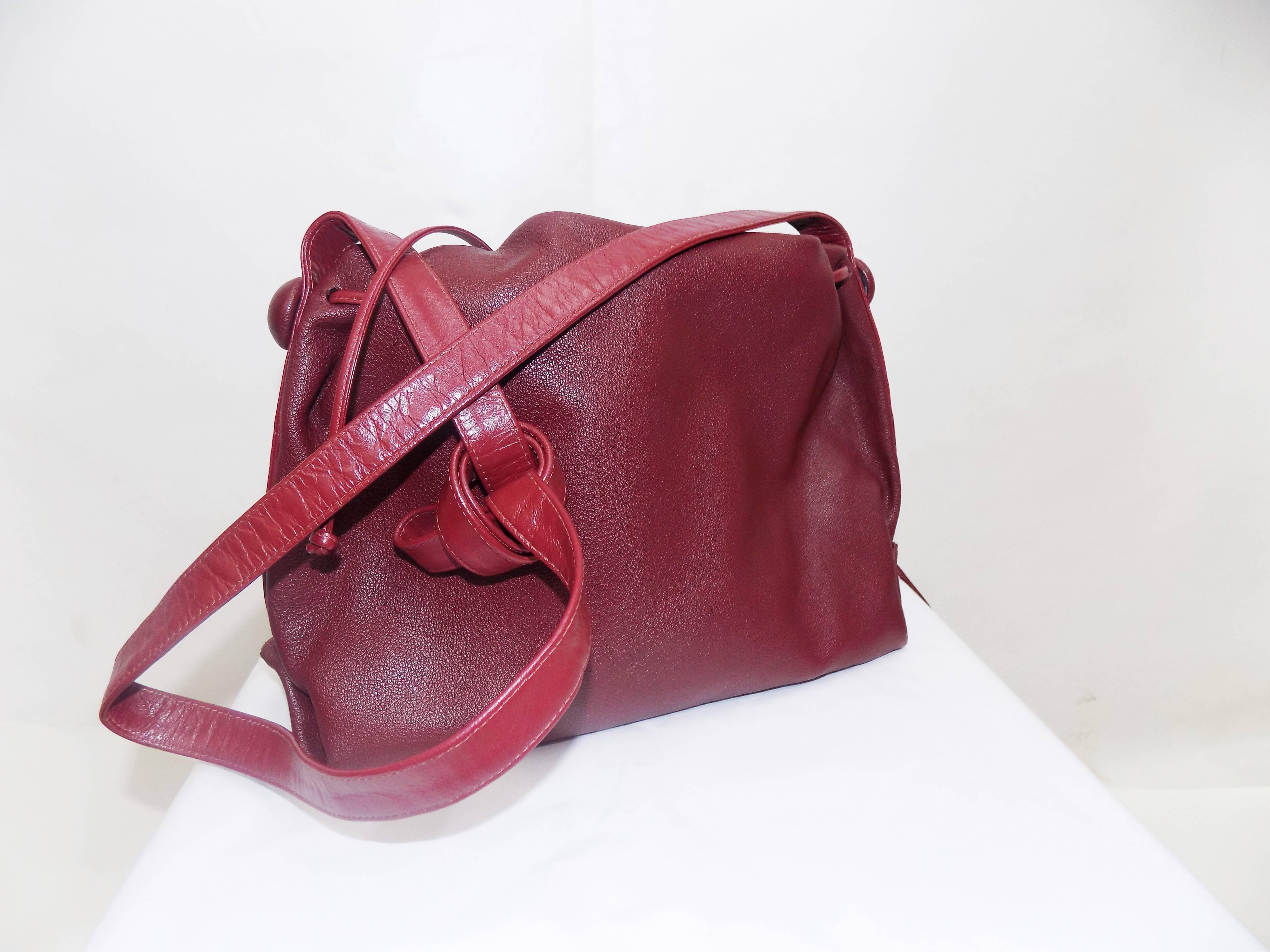 Carlos Falchi's signature beautiful burgundy red color  textured calfskin adjustable drawstring cross-body bag.Large size  measures 11" in length. The height measures 7", depth is 4". The shoulder strap "25 drop .. Available in