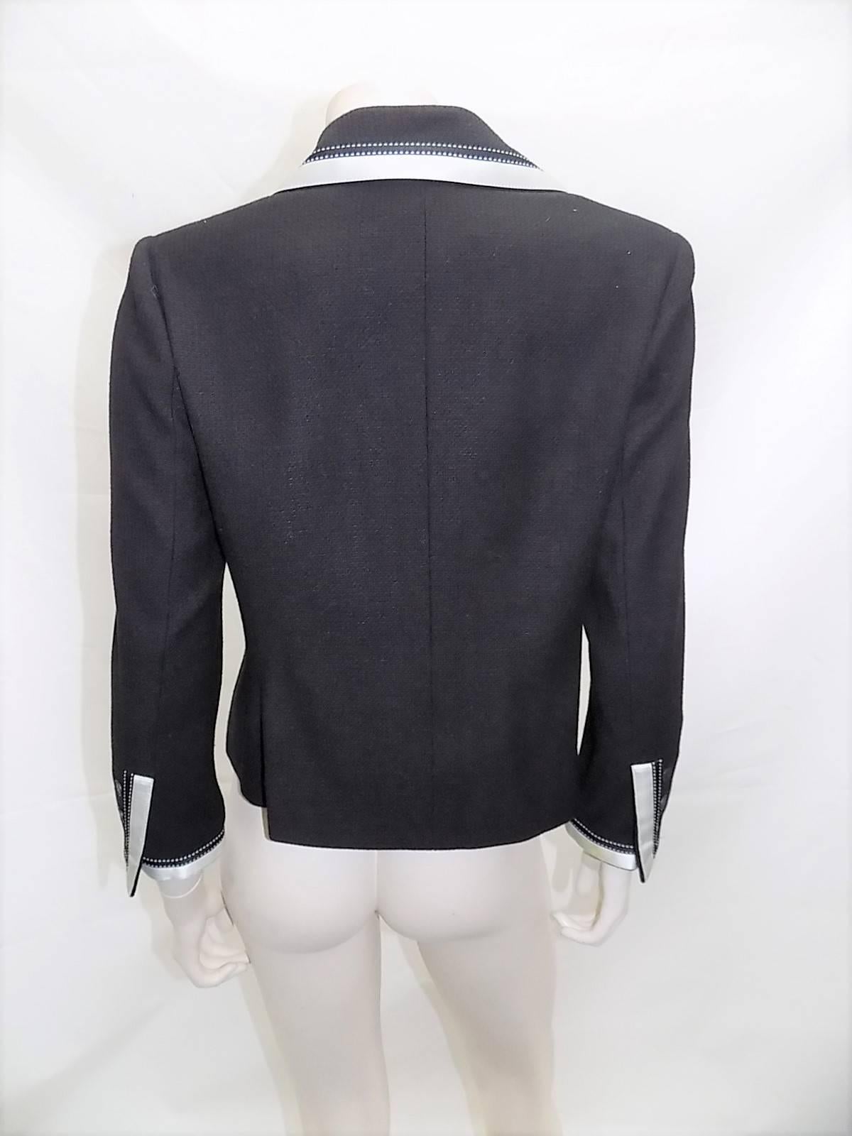 Beautiful black wool and silk blend jacket . Perfect for evening White silk trim  with white stitching  details .Three front buttons closure with Coco Chanel buttons. Two front patch pockets. . silk lining and silver metal bottom chain. Pristine